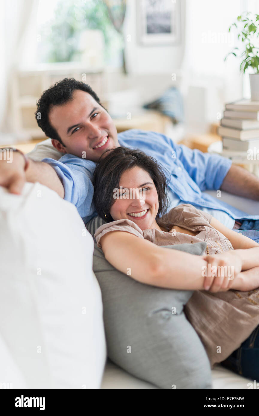 Hispanic couple relaxing together on sofa Banque D'Images