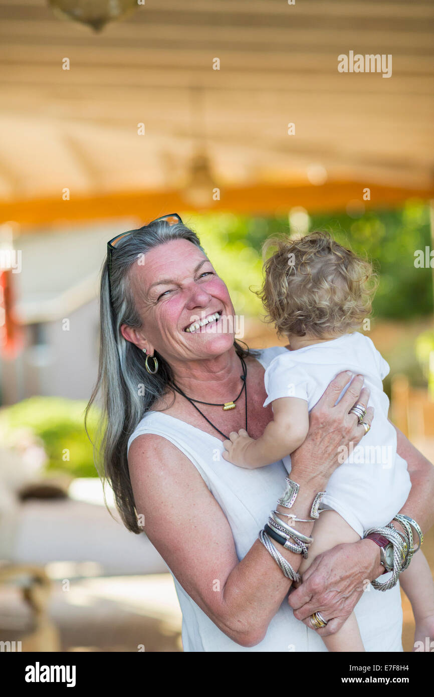 Caucasian woman holding petit-fils sur le porche Banque D'Images