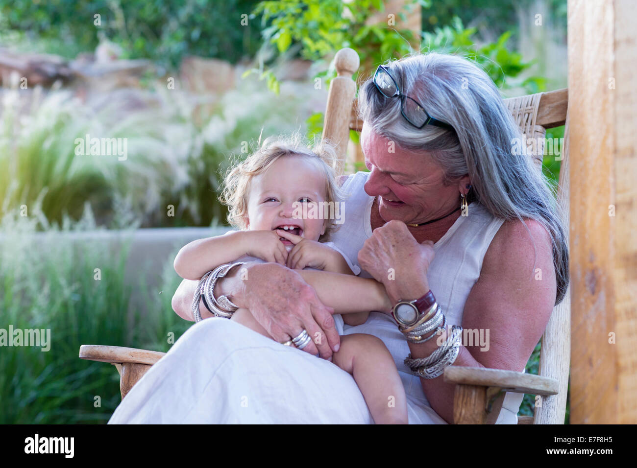 Caucasian woman holding petit-fils dans un fauteuil à bascule Banque D'Images