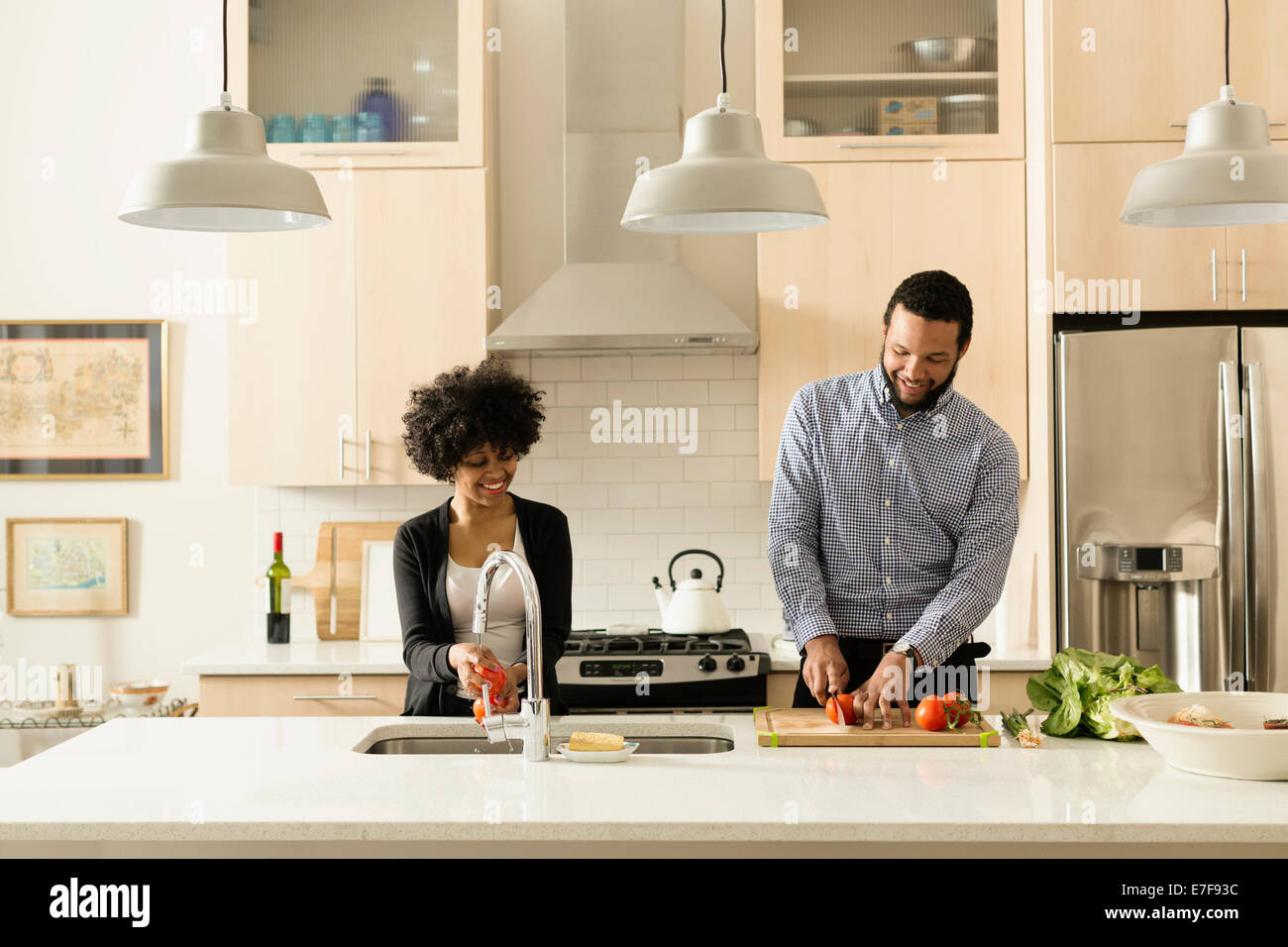 Mixed Race couple cooking together in kitchen Banque D'Images