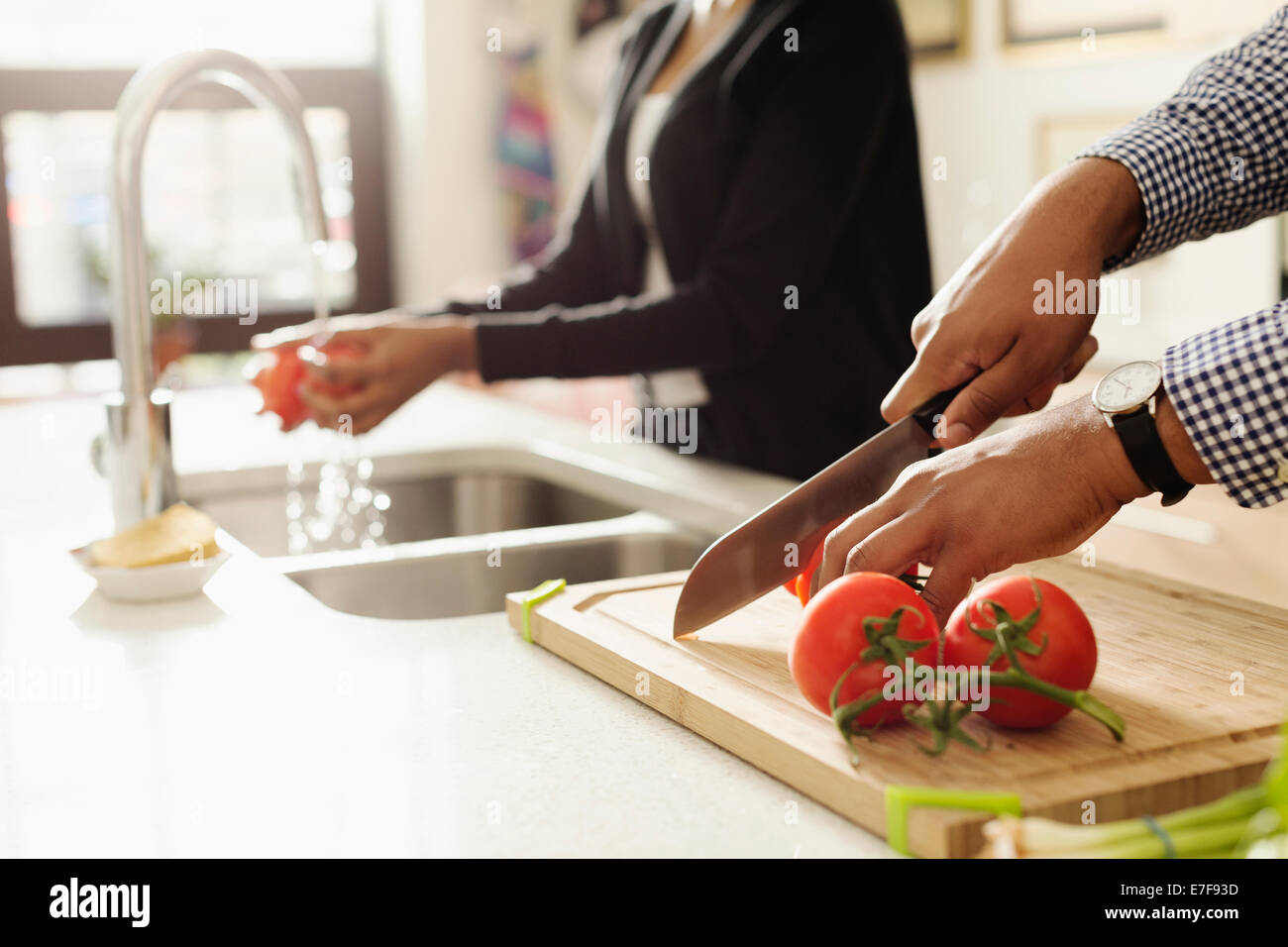 Mixed Race couple cooking together in kitchen Banque D'Images