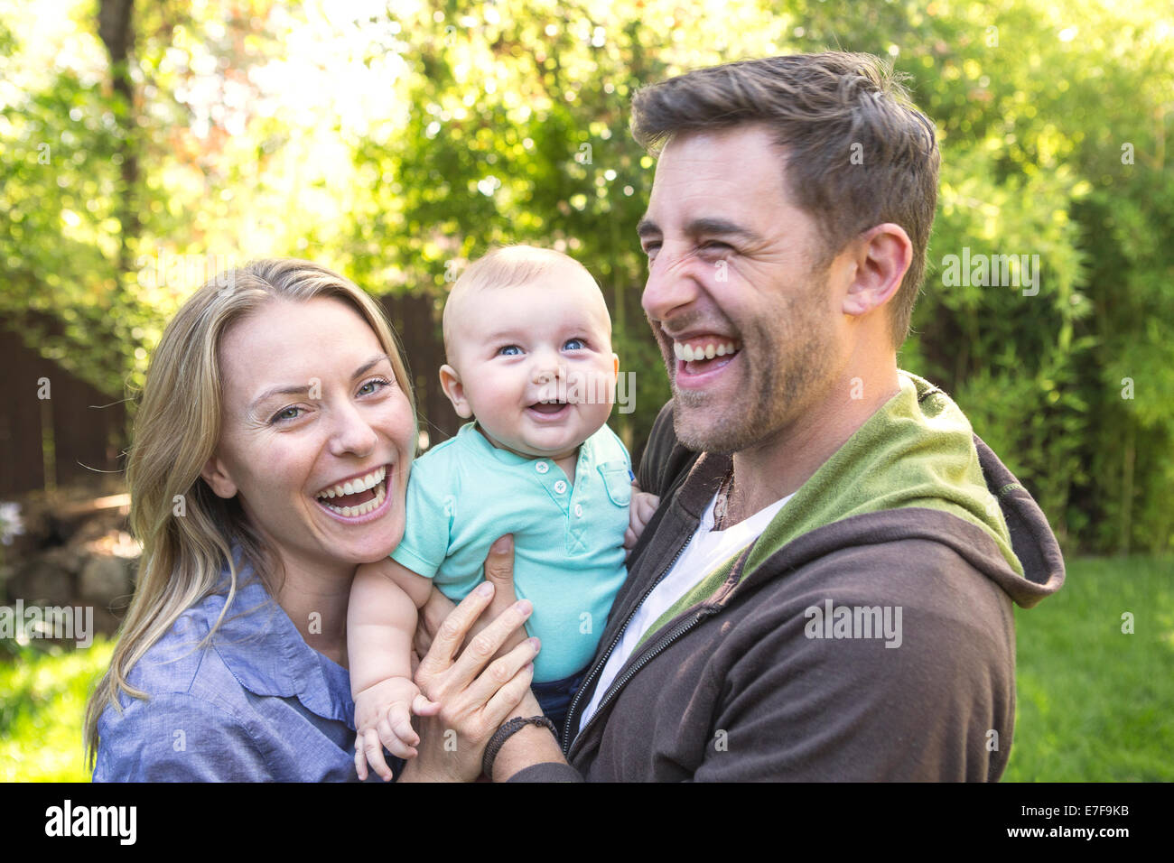 Caucasian couple holding baby in backyard Banque D'Images