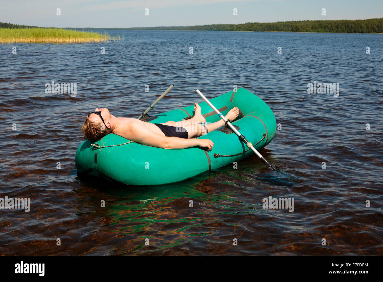 L'homme se reposant dans un bateau en caoutchouc Banque D'Images