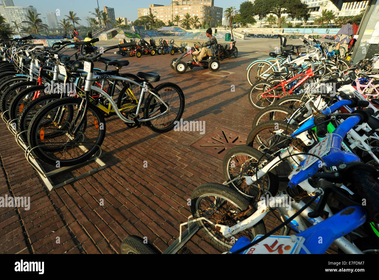 Durban, le KwaZulu-Natal, Afrique du Sud, seul homme adulte équitation Voiture à pédale à côté de rangées de stationnement des vélos de location sur beachfront Banque D'Images Durban, le KwaZulu-Natal, Afrique du Sud, seul homme adulte équitation Voiture à pédale à côté de rangées de stationnement des vélos de location sur beachfront Banque D'Images