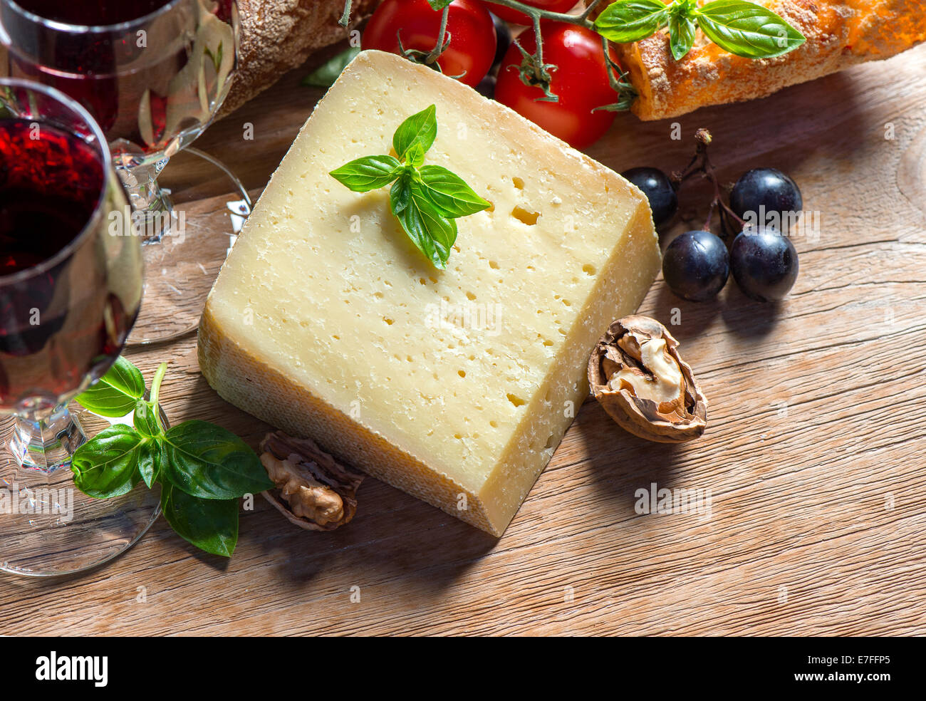 Vin rouge avec le fromage, les noix et les raisins. arrière-plan alimentaire à faible clés photo style. Banque D'Images