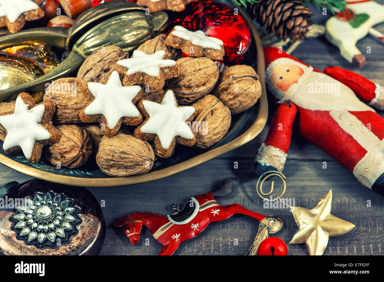 Les biscuits de Noël et les noix avec décorations vintage sur fond de bois. retro toned photo Banque D'Images