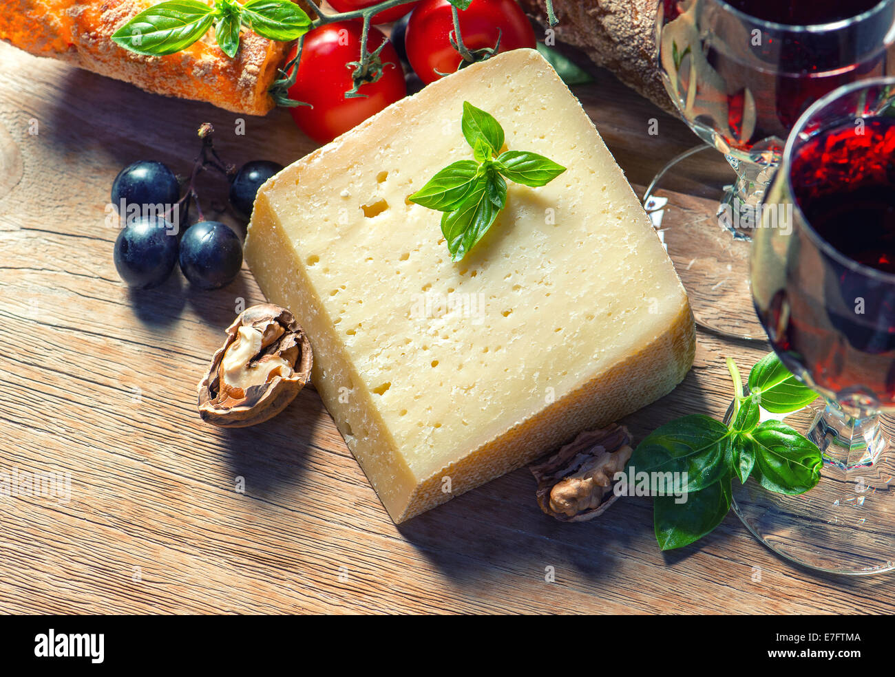 Vin rouge avec le fromage, les noix et les raisins. arrière-plan alimentaire à faible clés photo style. Banque D'Images