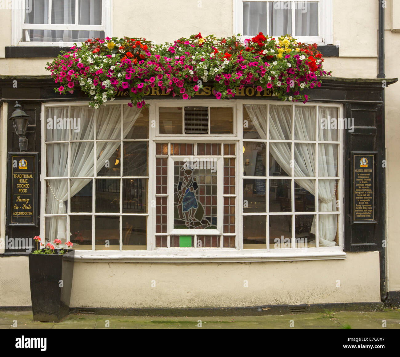 Fenêtre en baie de pub, Lord Nelson Hotel en anglais ville de Brigg avec grande fenêtre fort remplies de fleurs colorées en rouge et blanc - des annuelles pétunias Banque D'Images