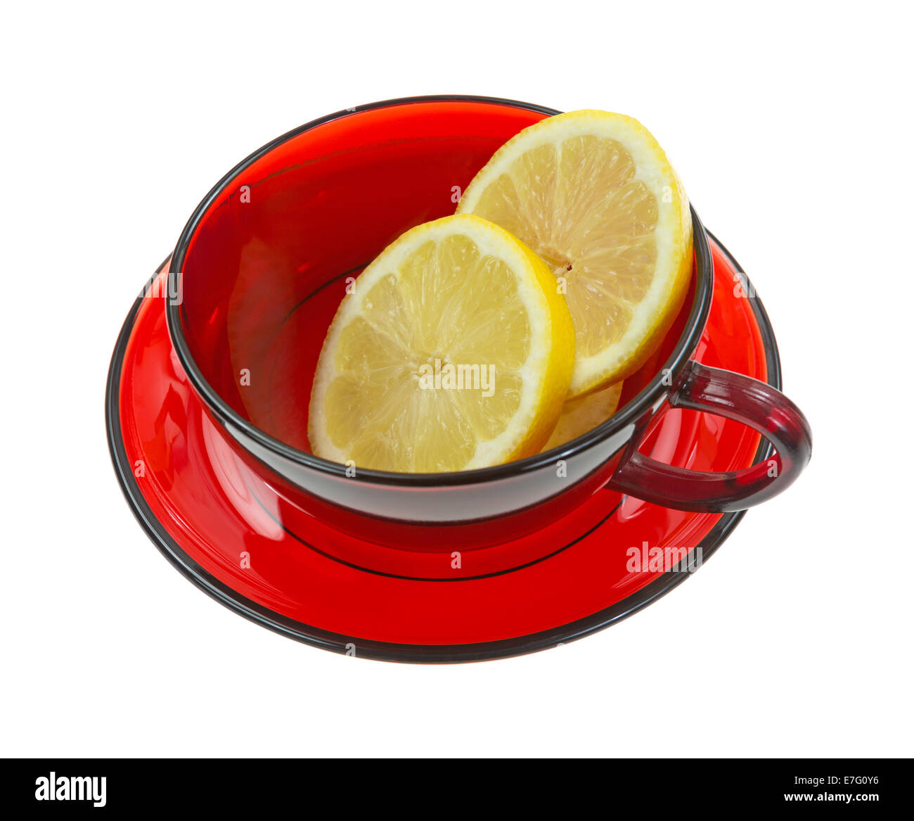 Des tranches de citron dans une tasse rouge vide avec une soucoupe sur un fond blanc. Banque D'Images