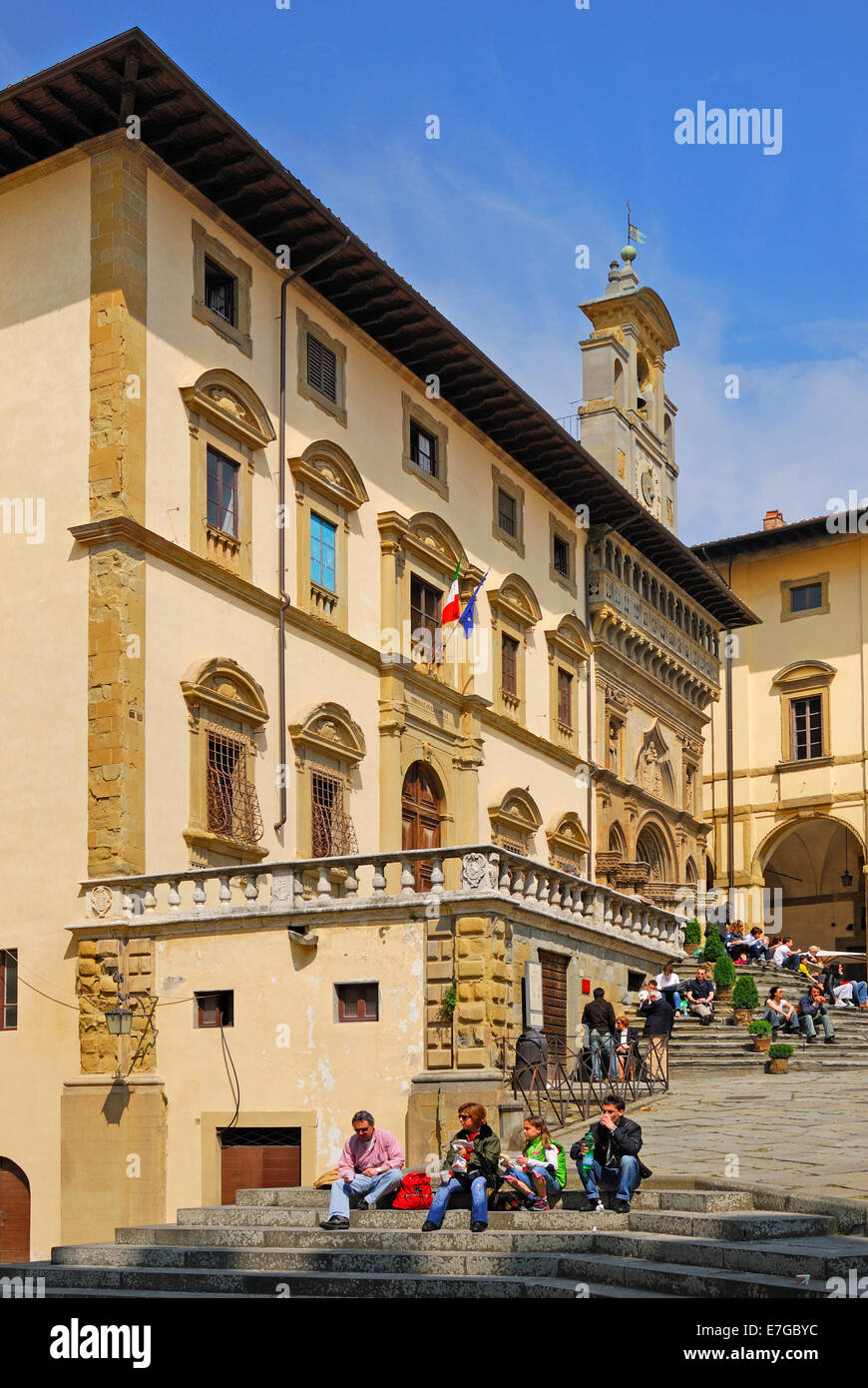 Arezzo, Toscane, Italie. Piazza Grande (Grande Place) des gens assis sur les marches du Palazzo della Fraternita dei Laici. Banque D'Images