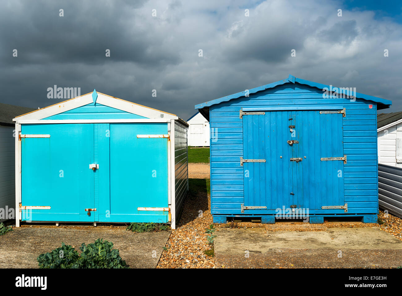 Cabines de plage bleue sous un ciel dramatique à St Leonards on Sea à Hastings, East Sussex Banque D'Images