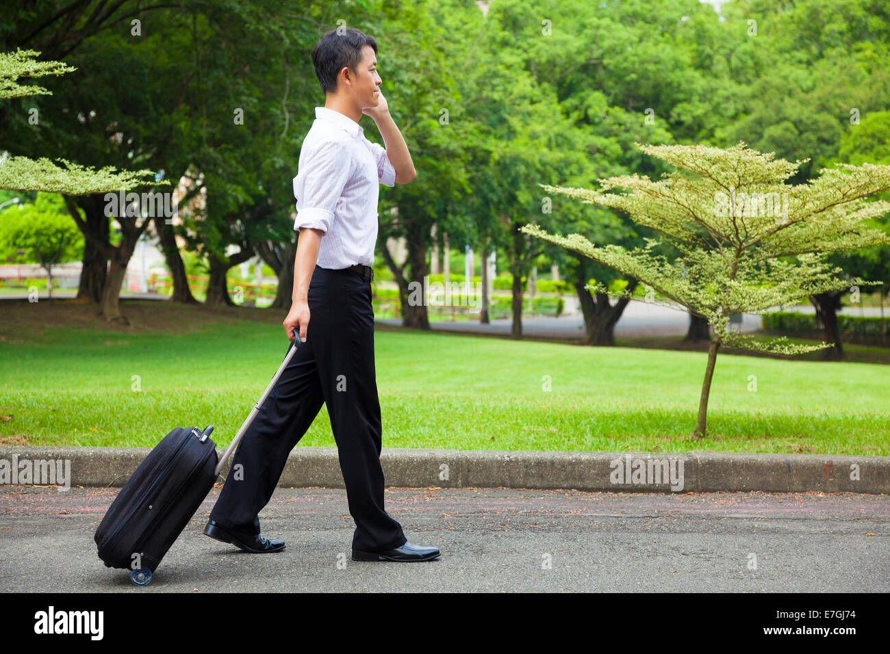 Businessman walking et à l'aide d'un téléphone sur la route Banque D'Images