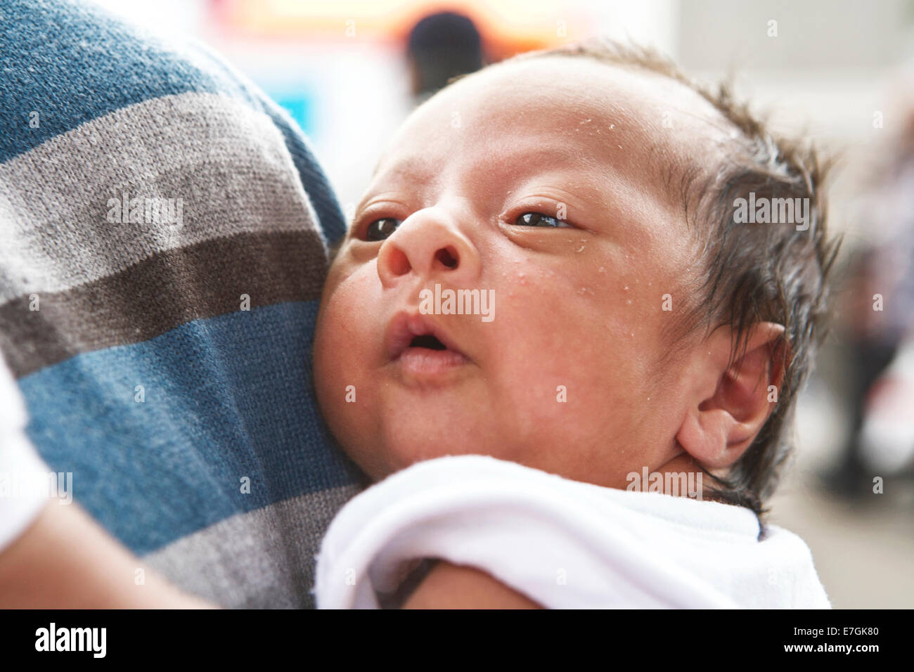 Jeune bébé reposant contre l'épaule de son père, Londres, UK Banque D'Images