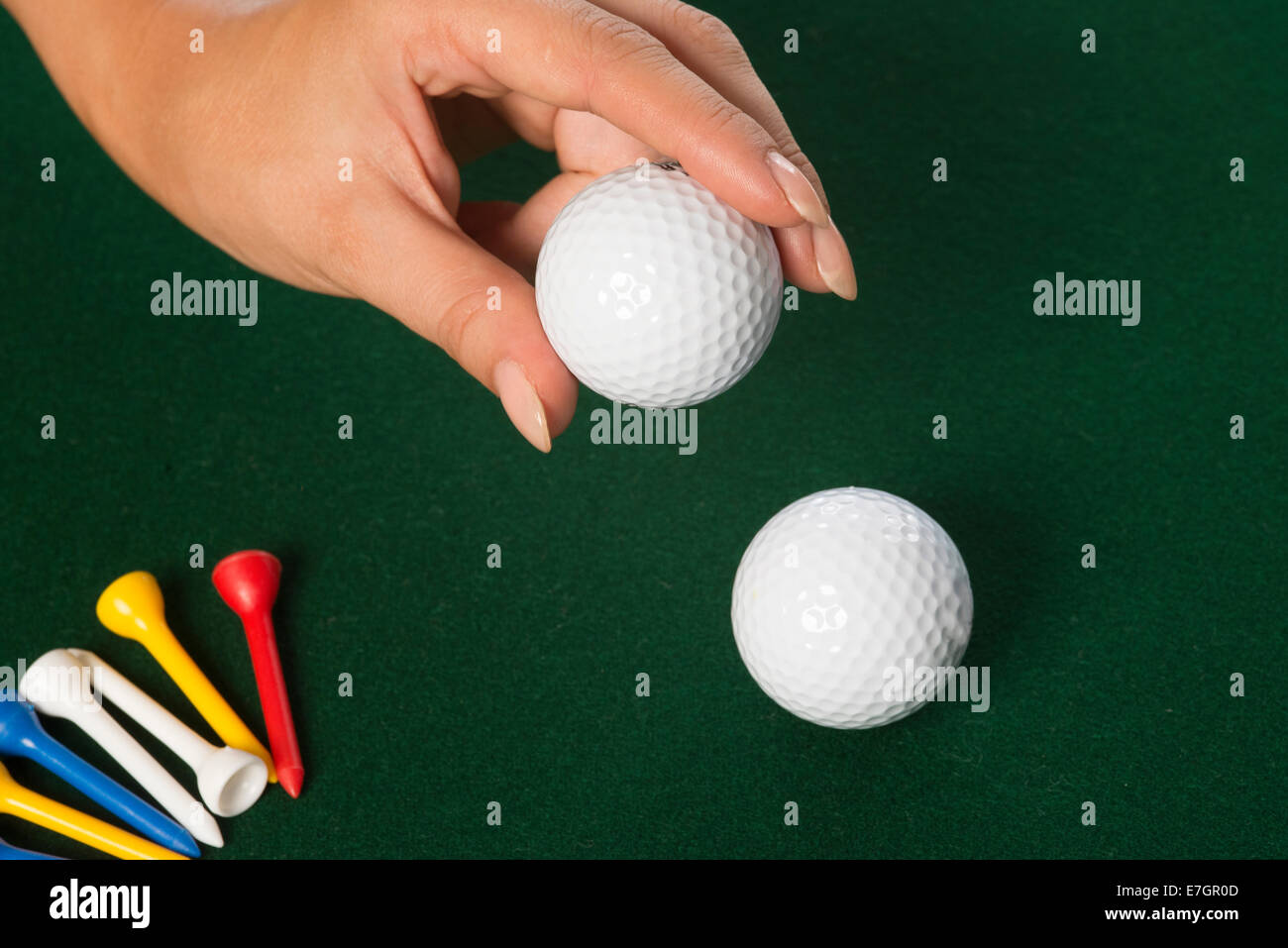 Équipement de golf Woman holding golf ball avec tees colorés Banque D'Images
