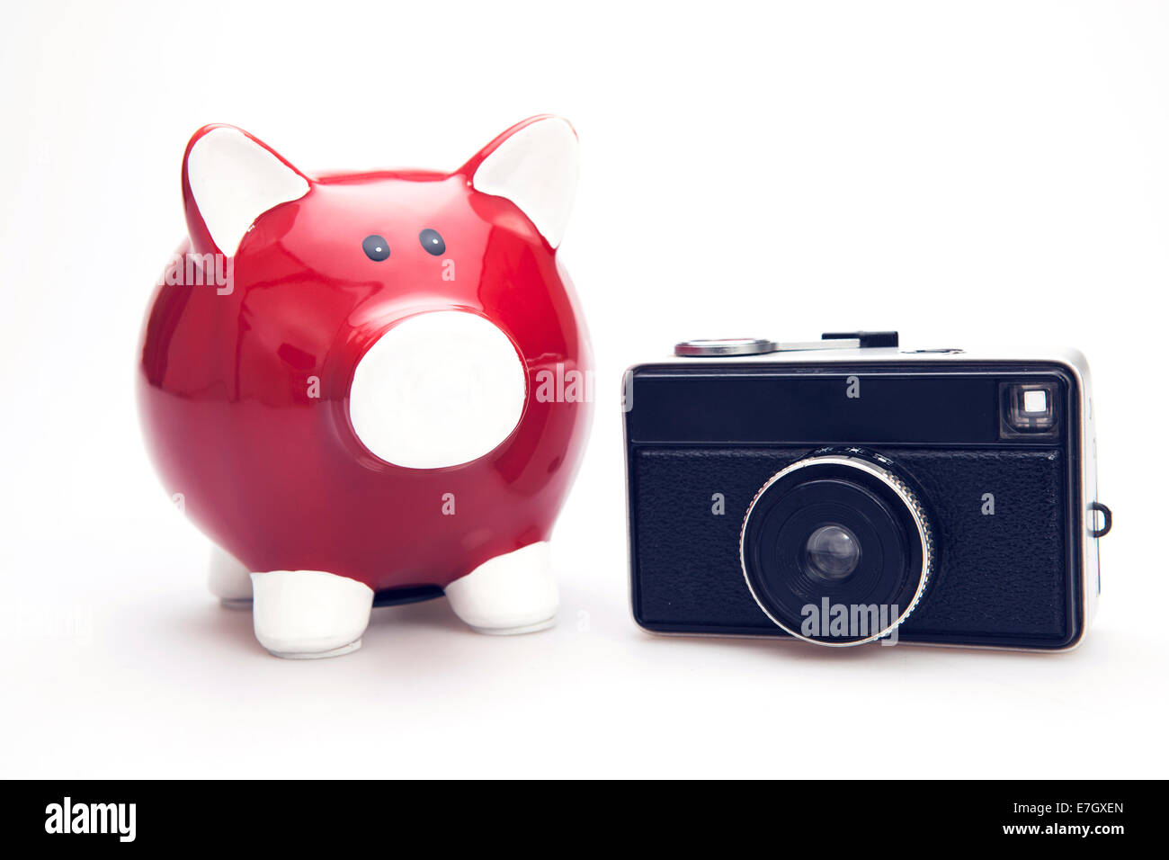 Tirelire rouge avec appareil photo rétro sur le fond blanc Banque D'Images