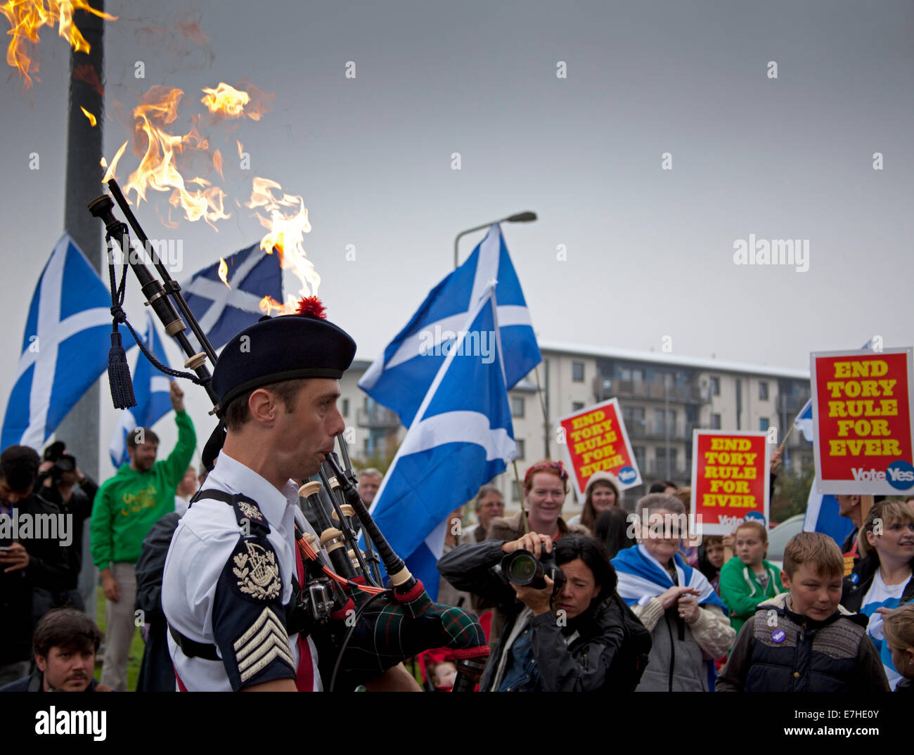Craigmillar, Édimbourg, Écosse. Référendum écossais. Septembre 18E2014. Piper Ryan Rendell de Las Vegas avec des flammes provenant de sa cornemuse dirige le Pro-Independence les résidents à travers les rues de Craigmillar, Édimbourg, Écosse sur l'Short à pied à la liberté' pour le bureau de vote d'encourager les résidents locaux de vote. Des affiches pour le mois de mars lire : "Le joueur de flûte d'Niddrie invite tous oui les électeurs à prendre part à la marche sur la promenade courte à la liberté", avant d'ajouter : ''Nous allons tous être Bravehearts !' Banque D'Images