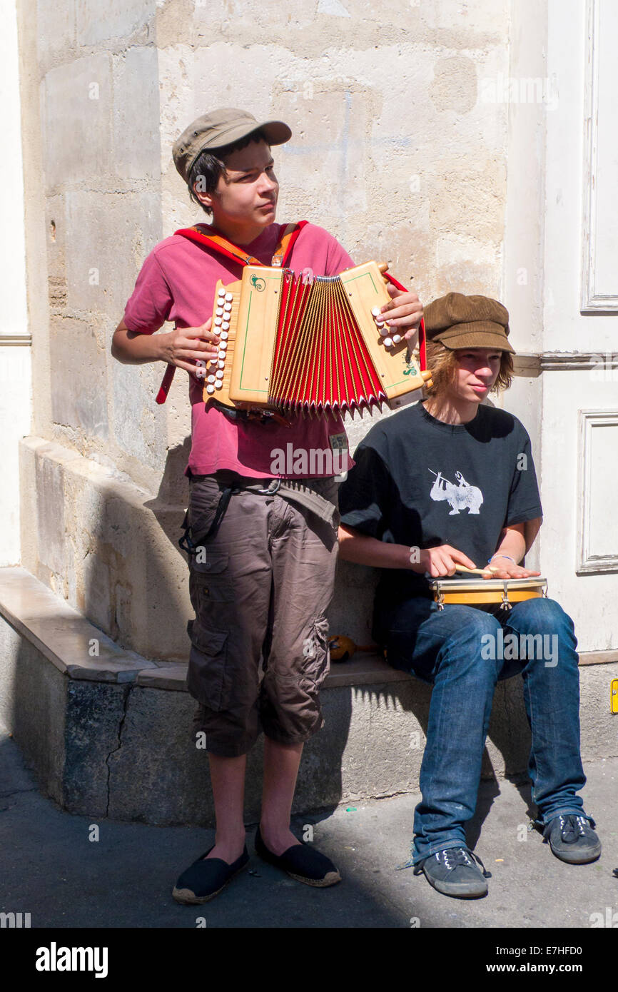 Garçon des rues musiciens jouant un accordéon et un tambourin dans les rues de Paris Banque D'Images