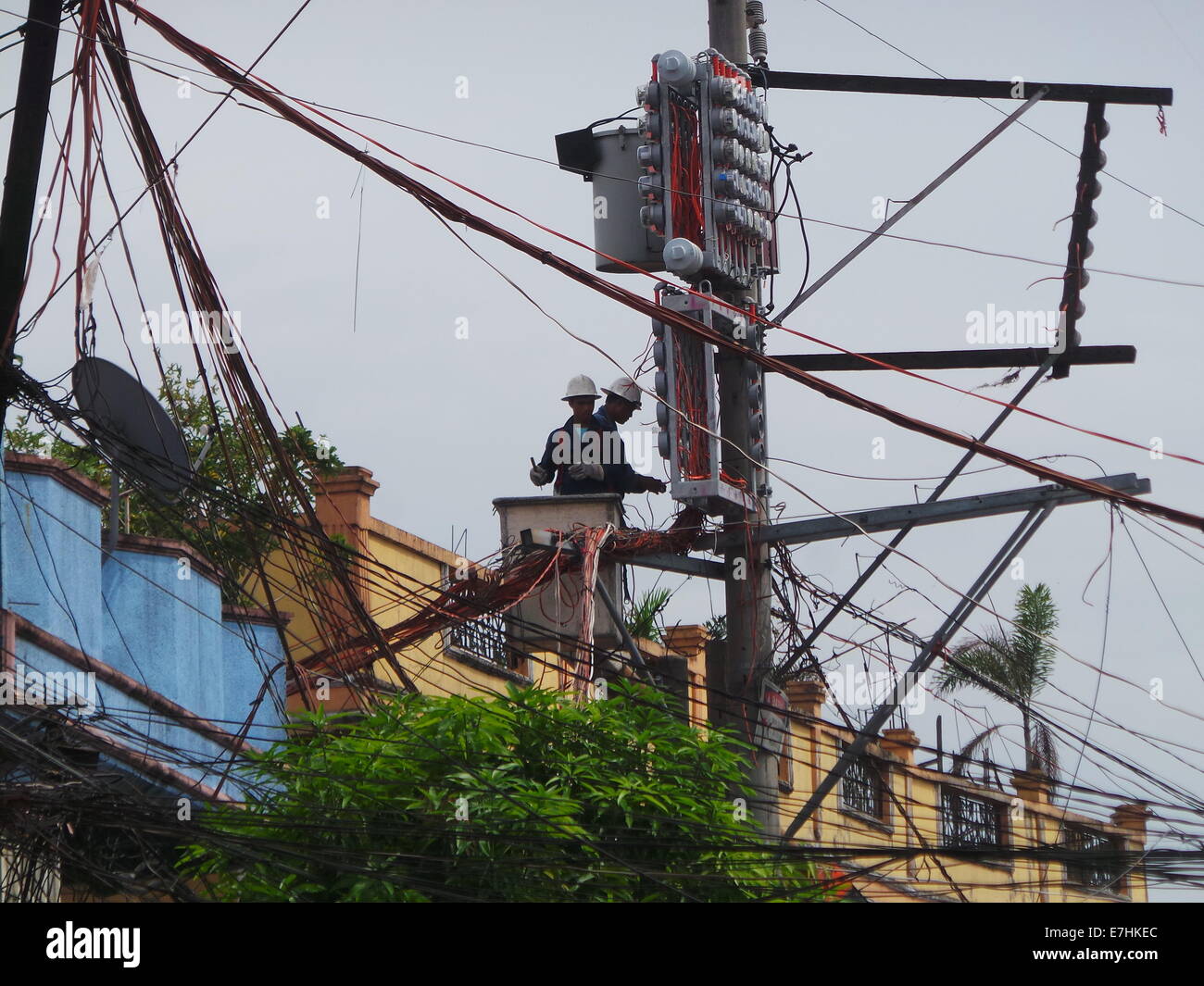 Manille, Philippines. 18 Septembre, 2014. Les hommes de Electric company fixant les câbles électriques. Luzon Visayas et îles des Philippines seront en situation de crise de l'énergie sur l'été 2015, selon le secrétaire de l'énergie Petilla de Jéricho. Une fois que le Président Aquino acquiert les pouvoirs d'urgence du Congrès, les consommateurs philippins vont durer plus d'augmentation de 20 centavo par kilowatt-heure. Les Philippines ont le plus haut coût de l'électricité dans la région Asie-Pacifique. © Sherbien Dacalanio / Alamy Live News Banque D'Images