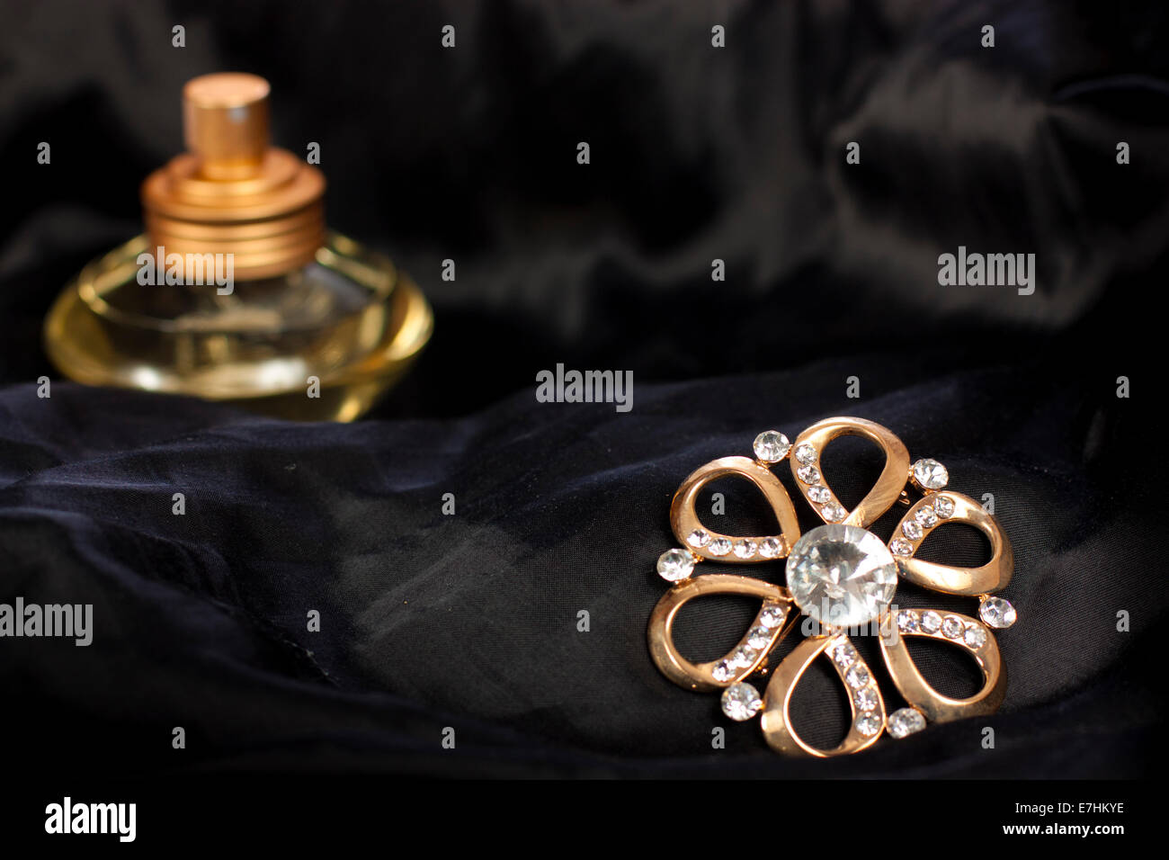 Bijoux élégant avec des brillants et du parfum sur la soie noire Banque D'Images