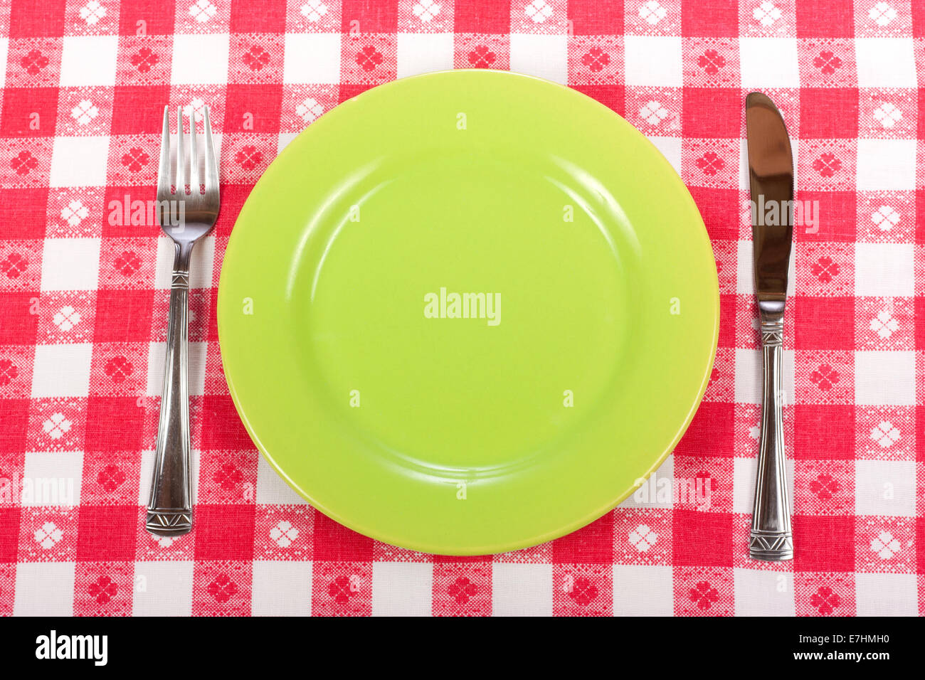 Couteau, assiette verte et rouge sur fourche vérifié cirée Banque D'Images