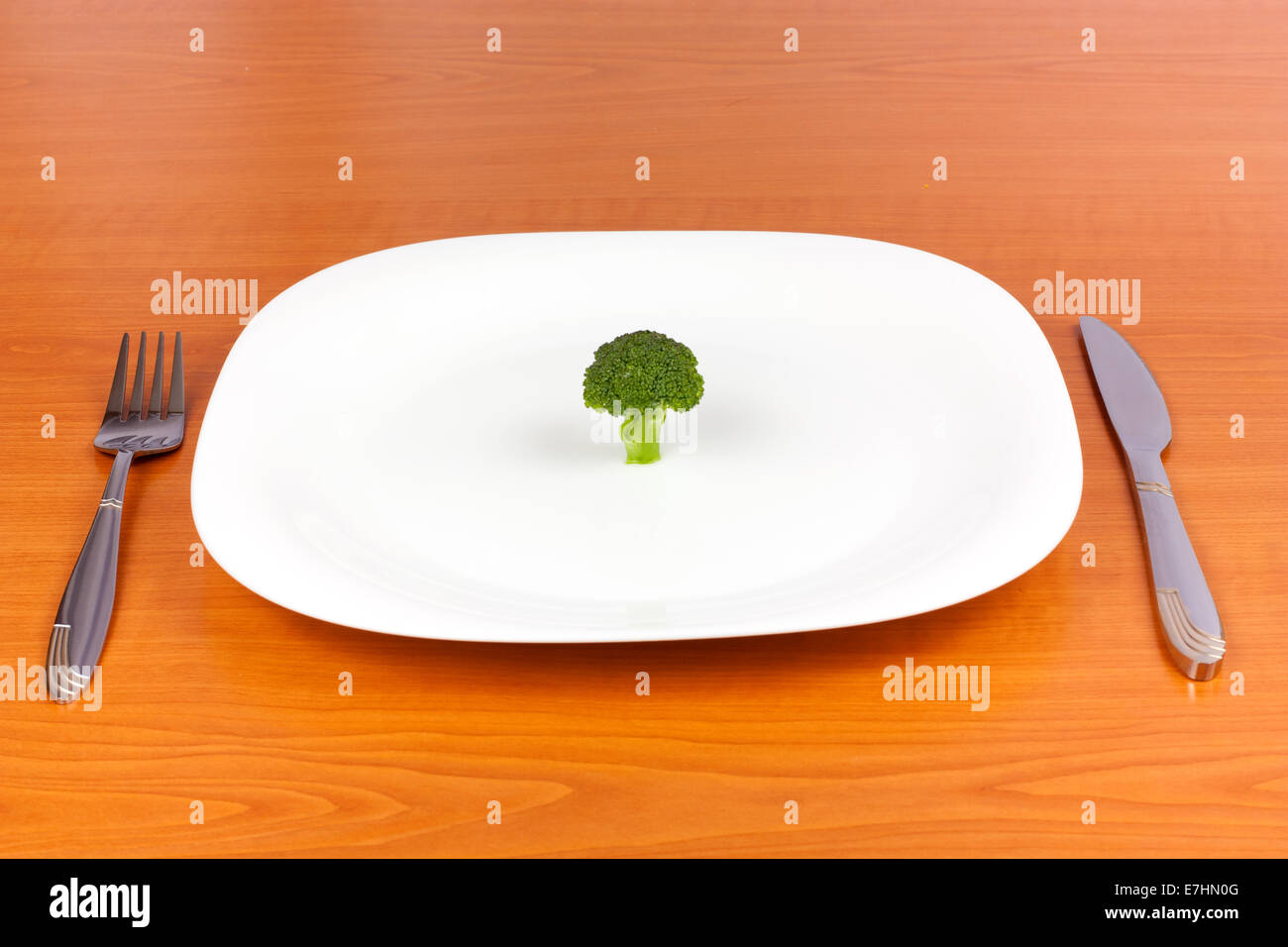 Le brocoli sur plaque avec fourchette et couteau sur fond de bois Banque D'Images