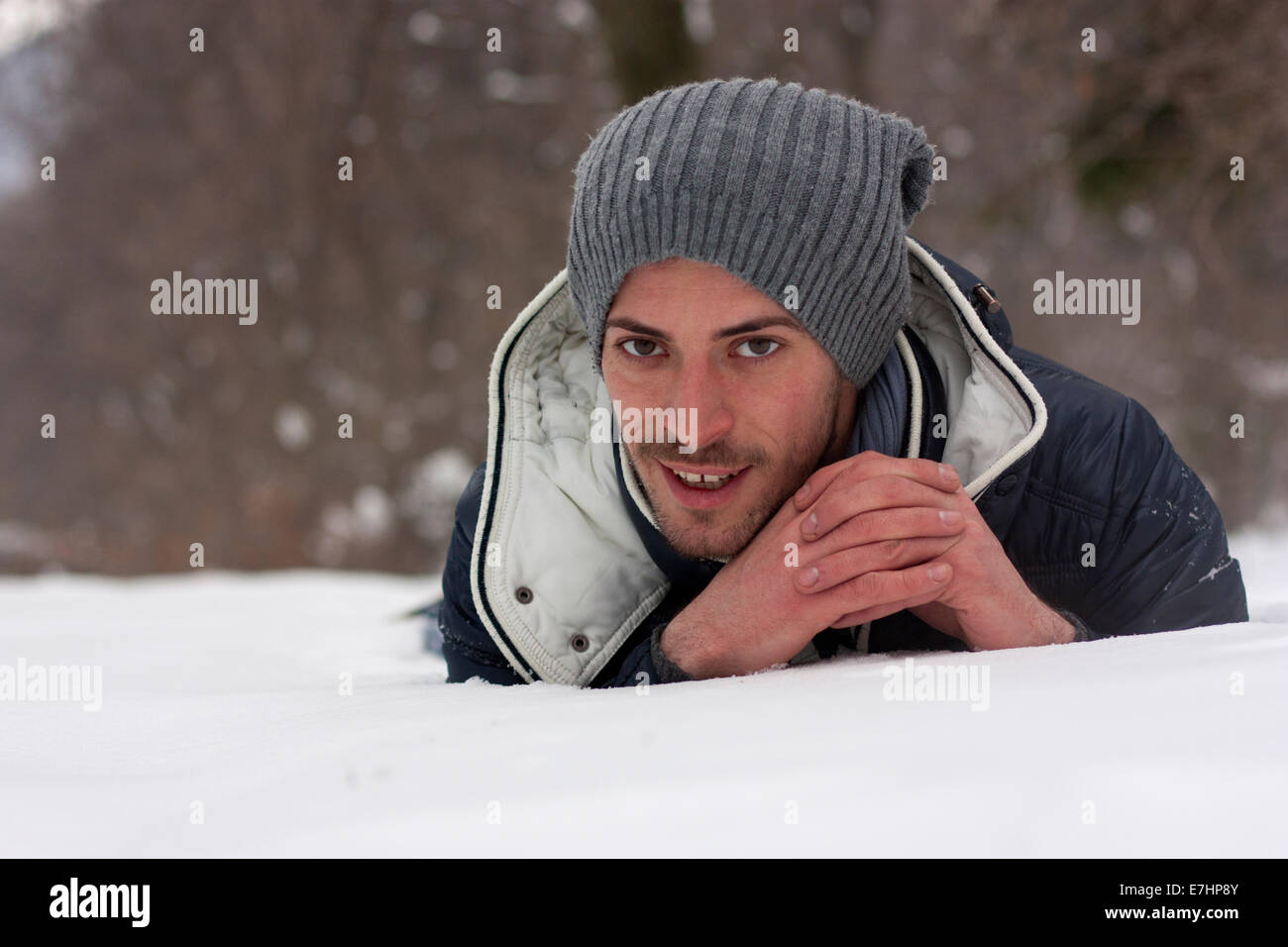 Portrait d'un jeune homme allongé sur la neige Banque D'Images