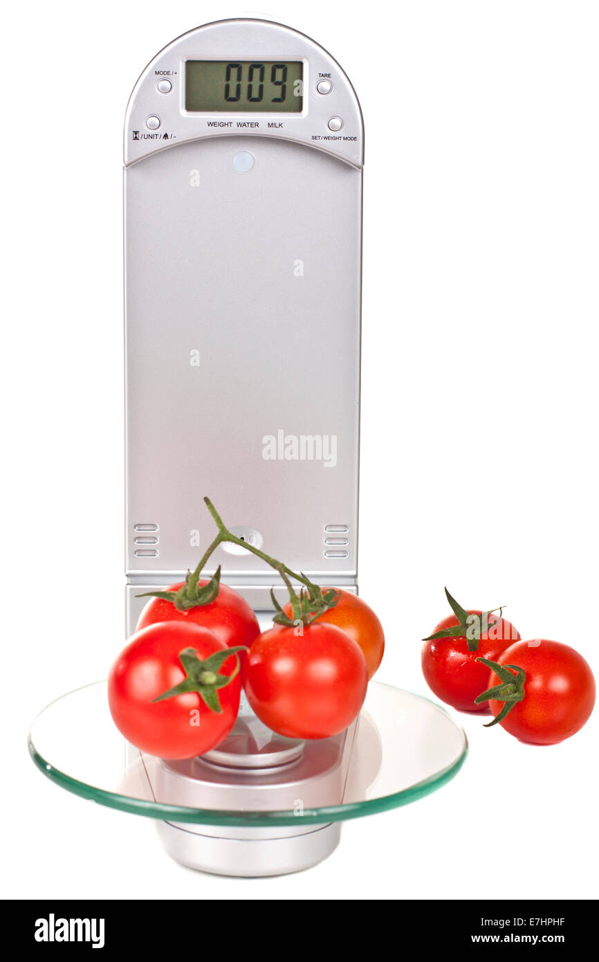 Tomates cerise sur balance de cuisine électronique isolé sur fond blanc Banque D'Images