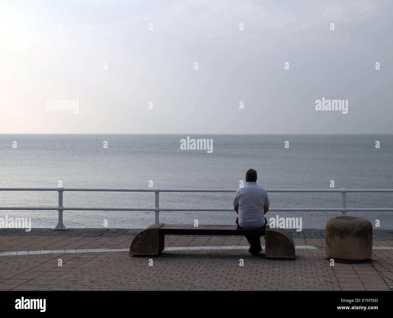 Aberystwyth, Pays de Galles, Royaume-Uni. 18 Septembre, 2014. Un homme est assis seul sur la Promenade à Aberystwyth donnant sur un paysage marin, gris avec pluie prévue pour la région au cours des prochains jours. Crédit : John Gilbey/Alamy Live News Banque D'Images