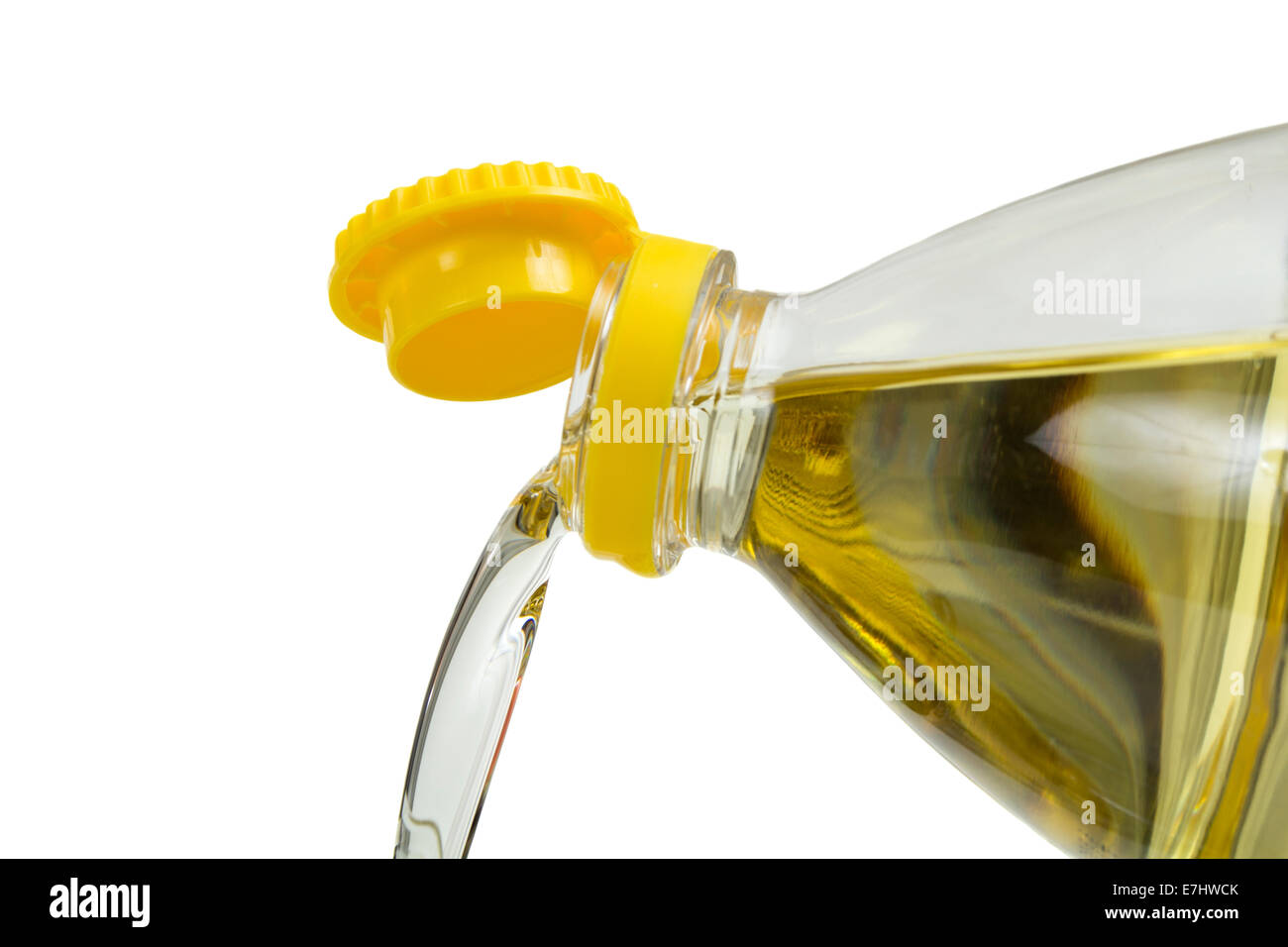 On verse de l'huile de tournesol à partir de bouteille en plastique isolé sur fond blanc Banque D'Images