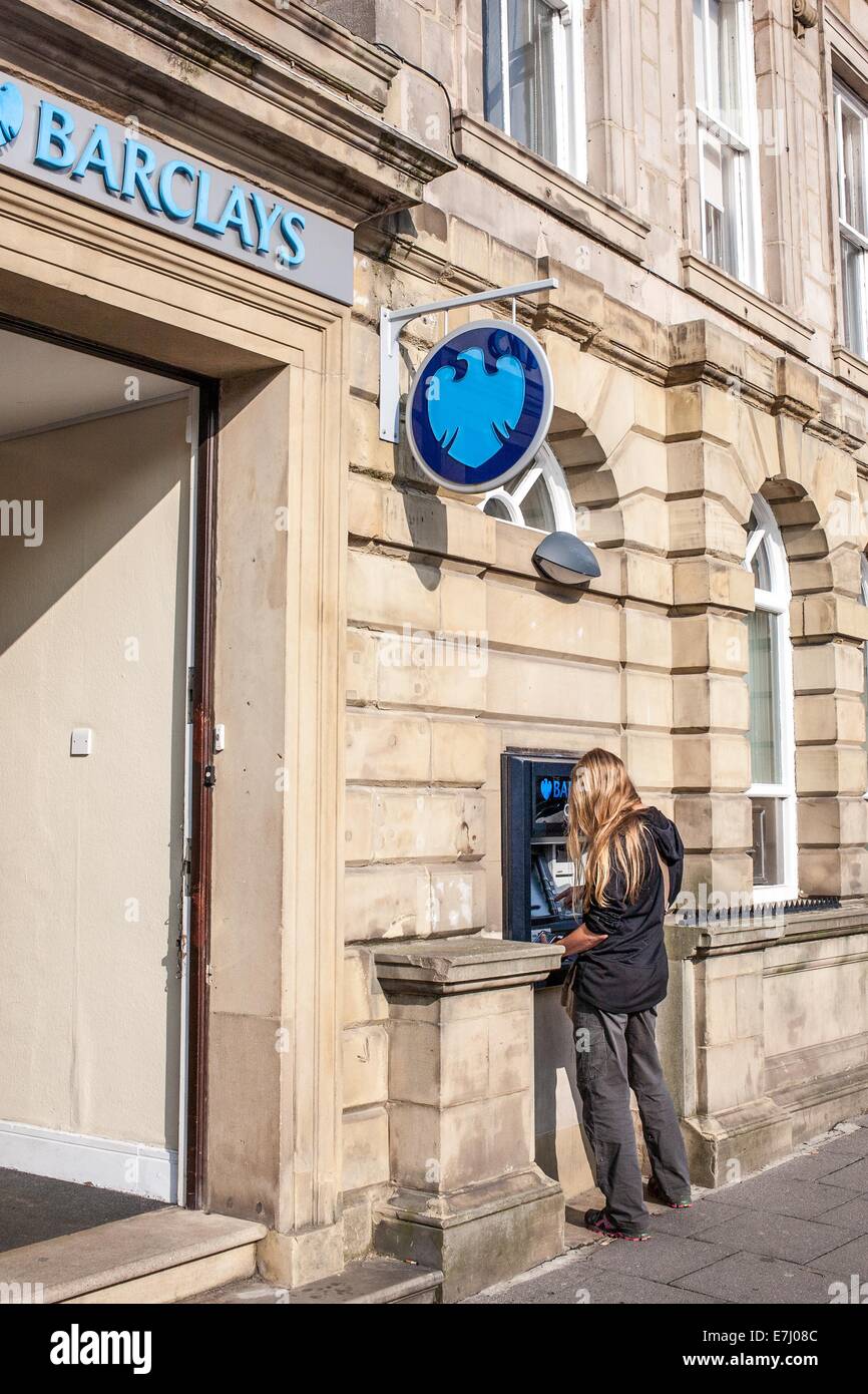 Une femme à l'aide d'un distributeur automatique de Barclays cash machine à Alnwick Northumberland Royaume-uni Banque D'Images