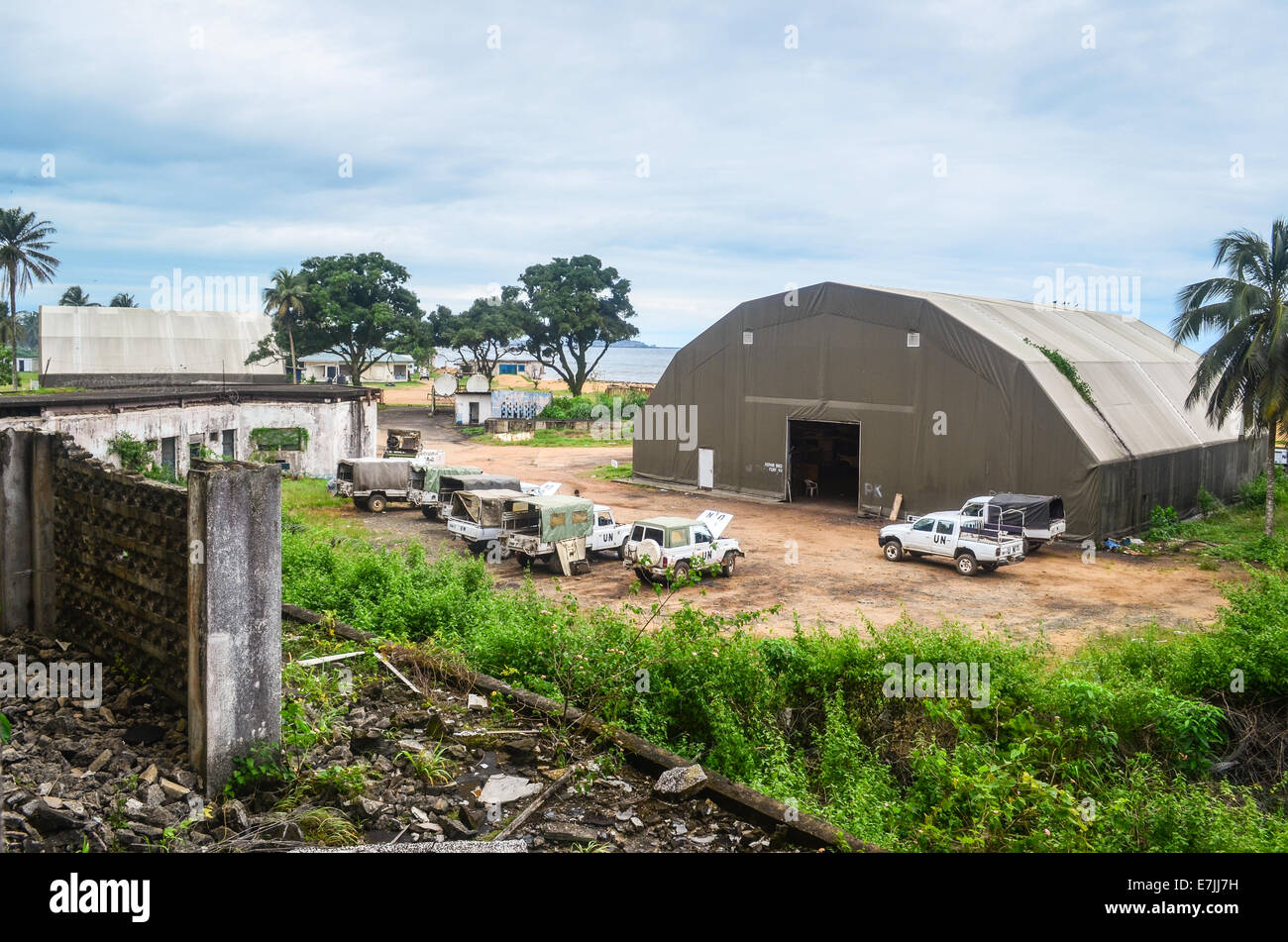 Véhicules et d'un hangar un camp à Monrovia, Libéria, vu du haut des ruines de l'Hôtel Africa Banque D'Images