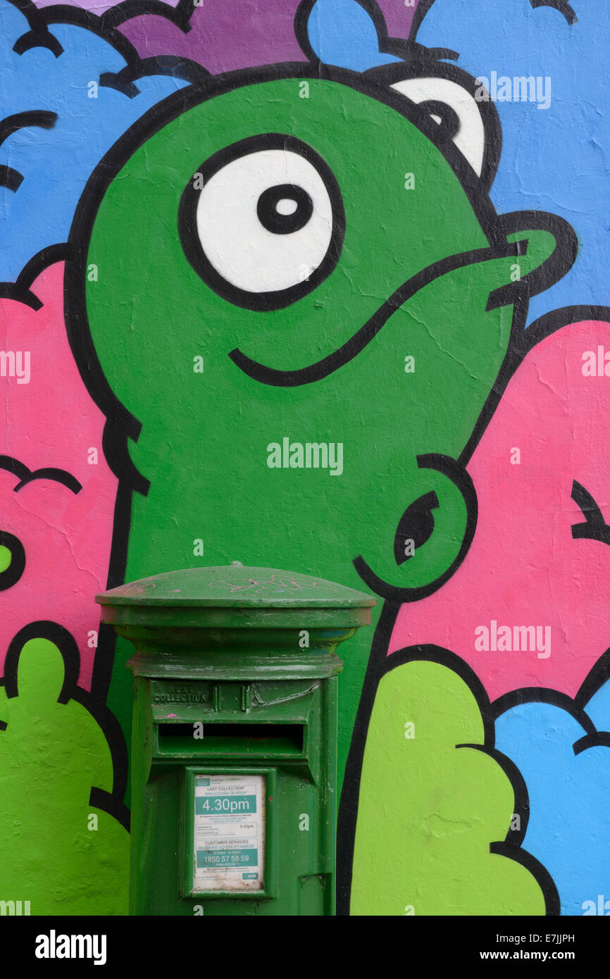 Un Irlandais green postbox incorporés dans une fresque sur un mur à Cork, Irlande. Banque D'Images