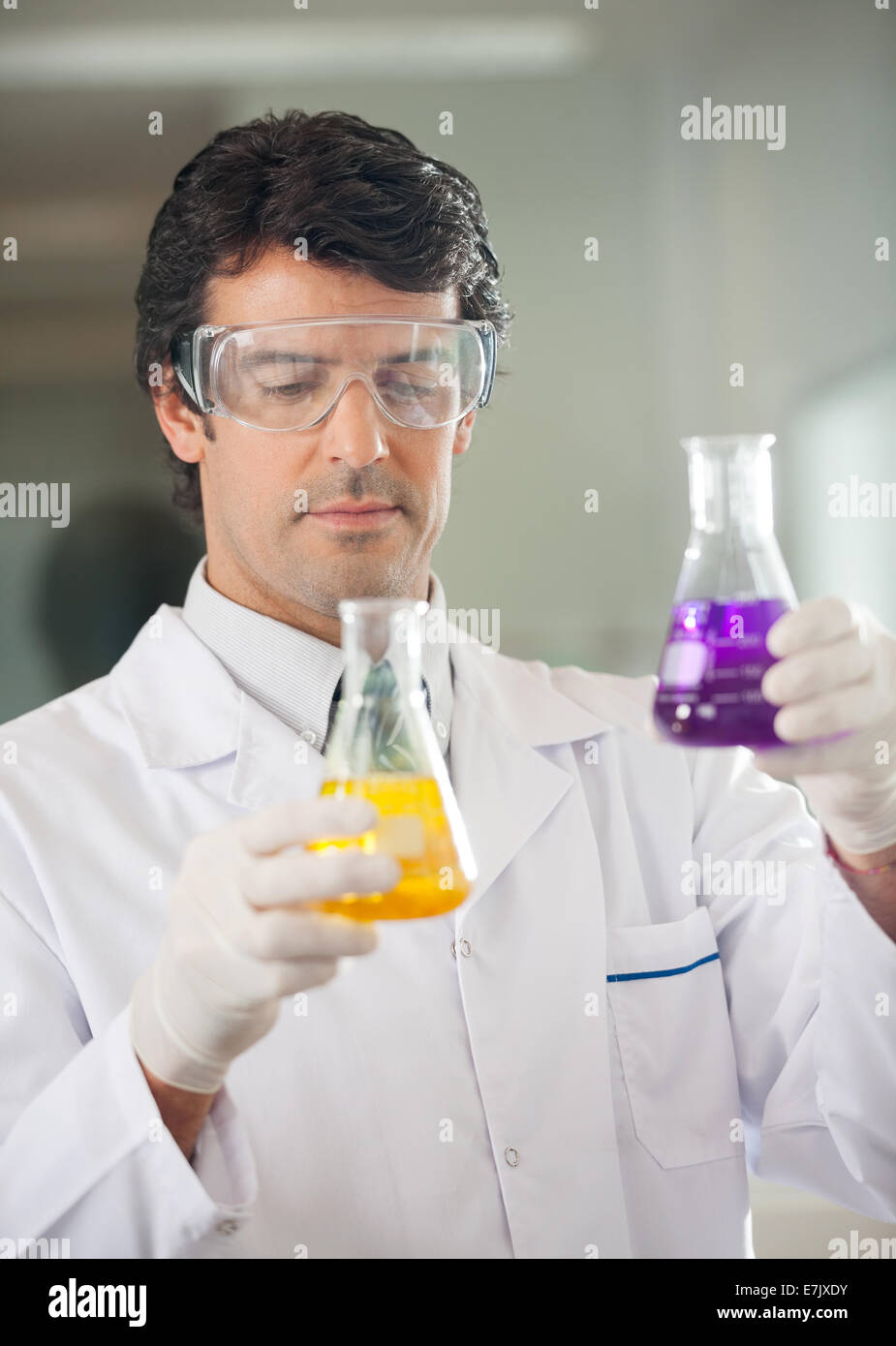 Scientist examining flacons avec différents produits chimiques Banque D'Images