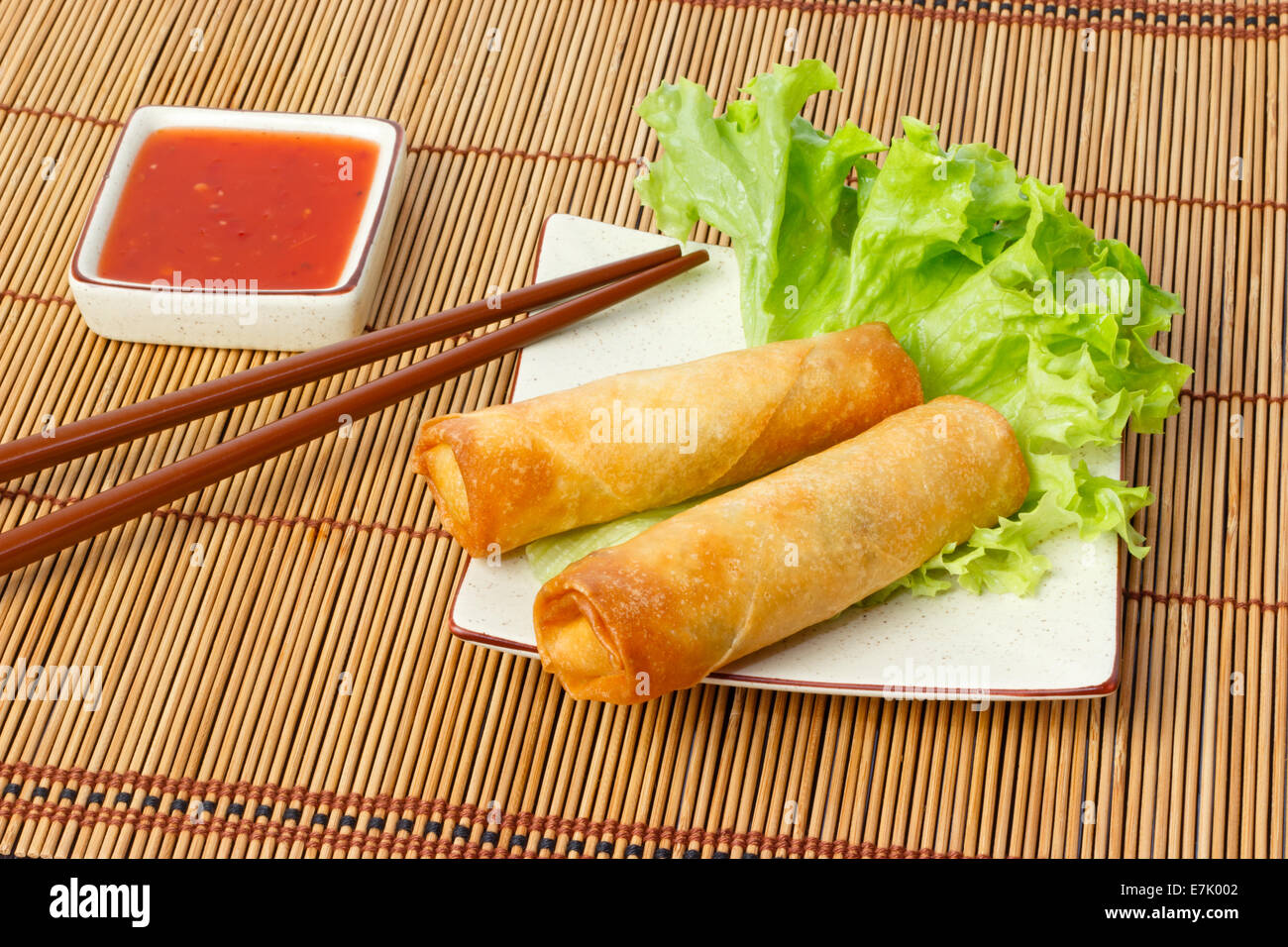 Deux rouleaux de printemps frits dans un plat servi avec sauce chili Banque D'Images