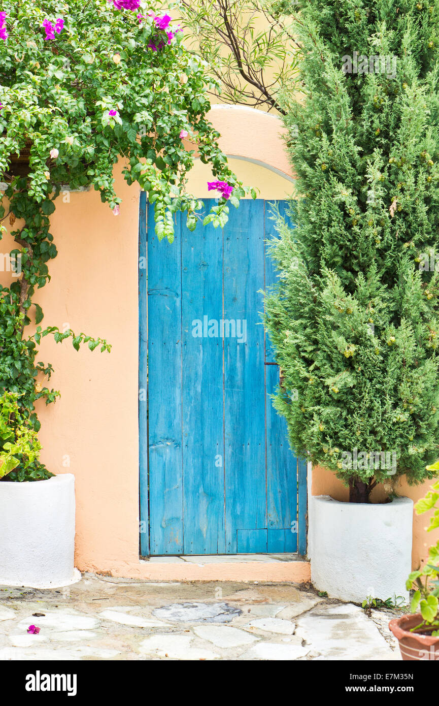 Porte bleue dans une maison grecque de bougainvilliers Banque D'Images