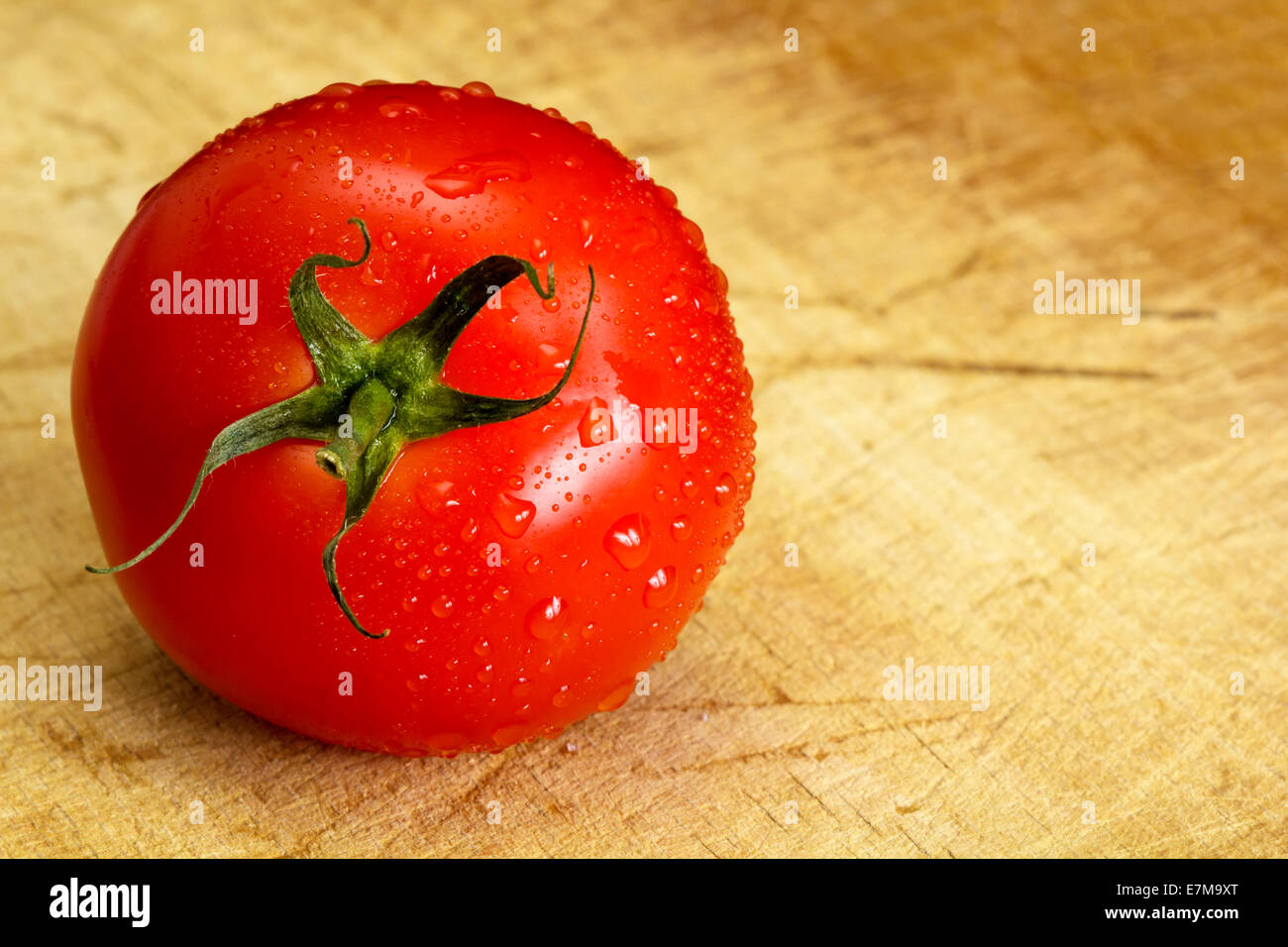 Une tomate rouge mûre est humide avec des gouttelettes d'eau Banque D'Images