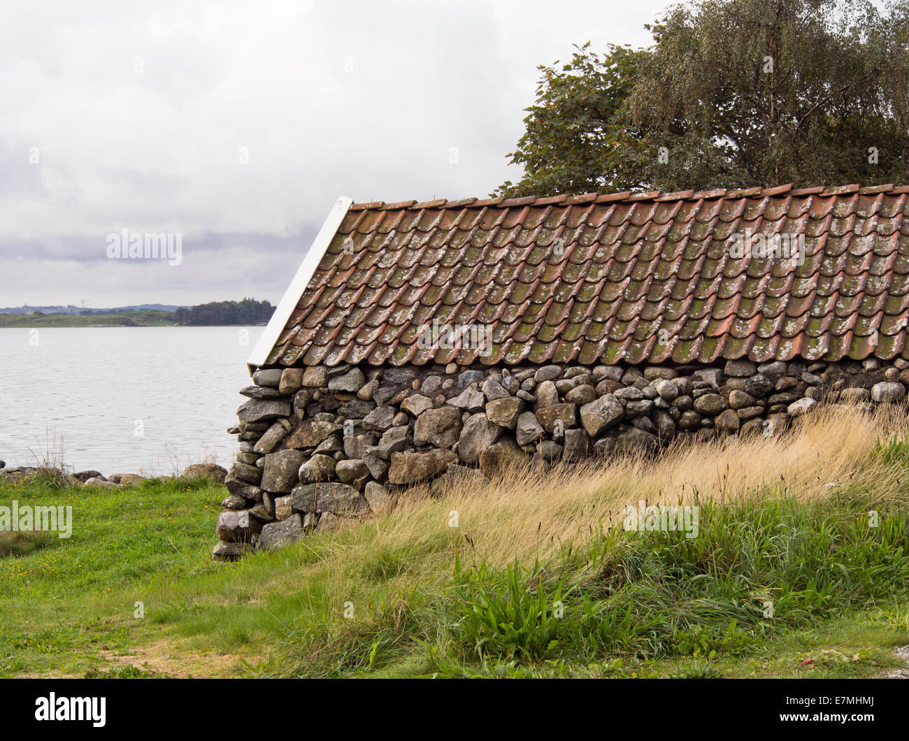 Traditionnellement construit un hangar à bateaux, mur en pierre et toit de tuiles, Stavanger Norvège Jæren Banque D'Images
