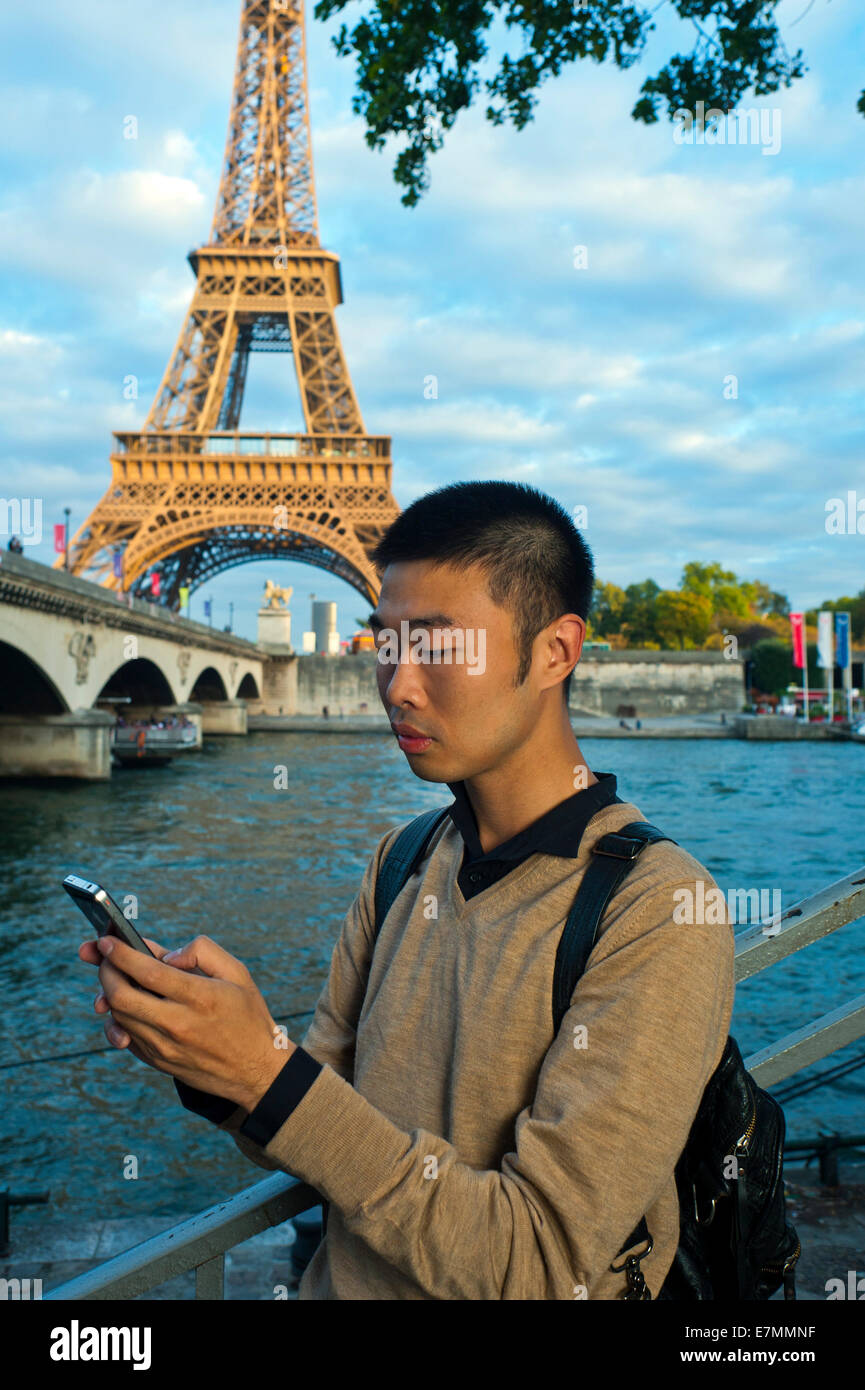 paris, France, jeune Chinois, Portrait, utilisation du smartphone i-Phone, téléphone, près de la Tour Eiffel, Seine, produits technologiques été Banque D'Images