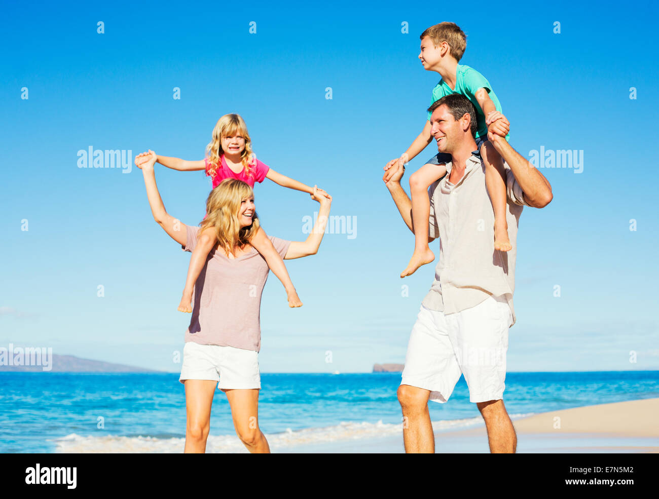 Famille de quatre heureux sain s'Amusant on Tropical Beach Banque D'Images