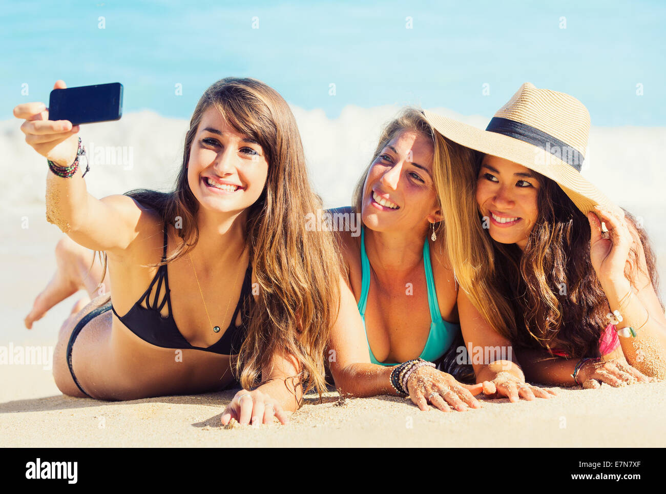 Les filles s'amuser à la plage taking self portrait with smart phone. Vie d'été. Banque D'Images