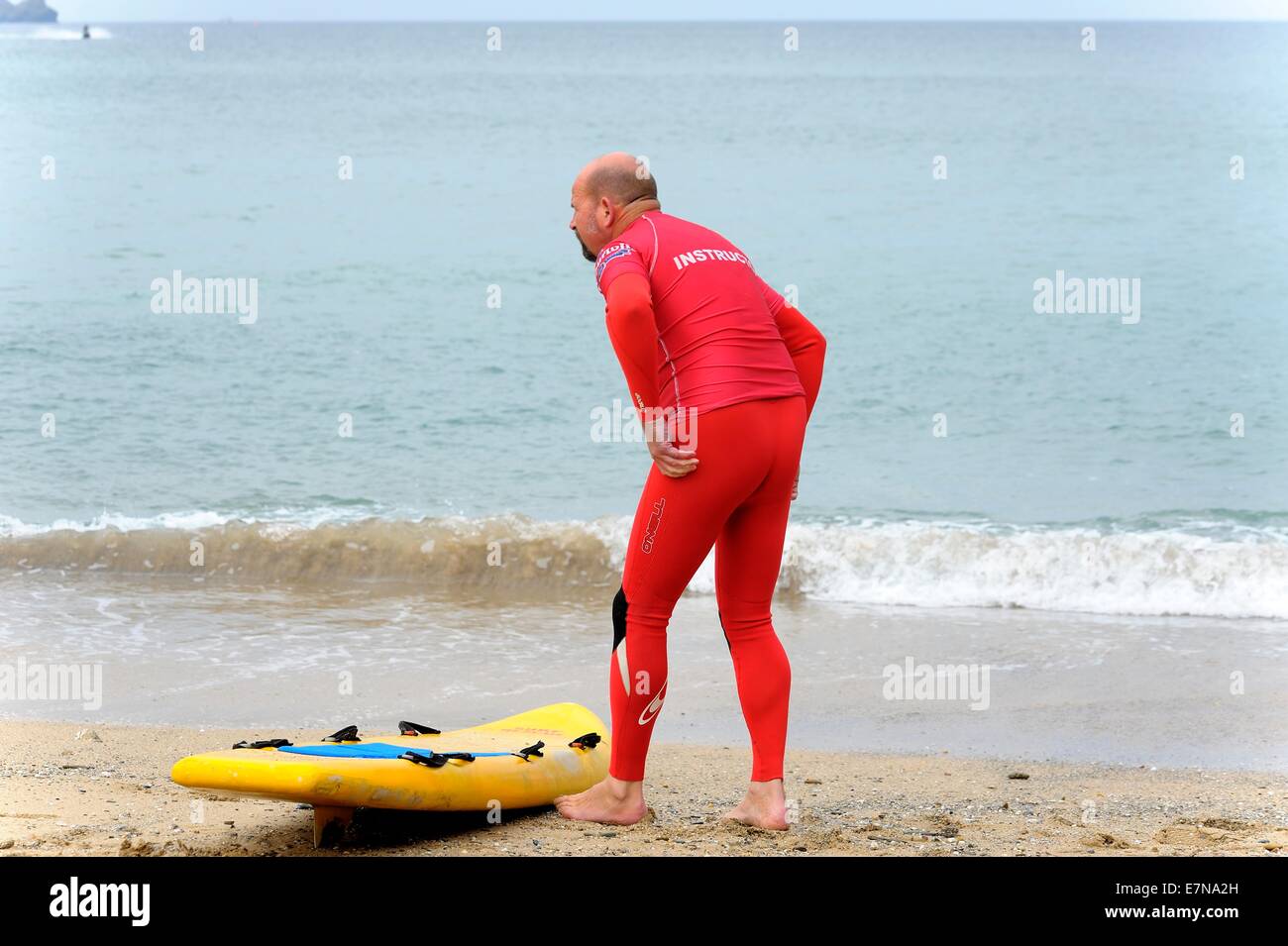 Un instructeur de surf faisant des exercices d'échauffement Newquay Cornwall uk Banque D'Images