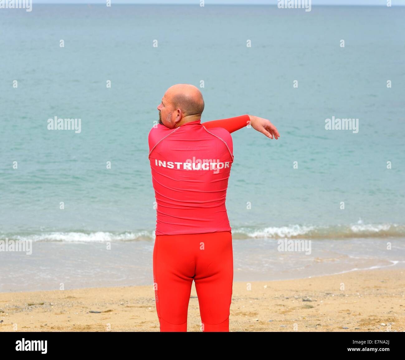 Un instructeur de surf faisant des exercices d'échauffement Newquay Cornwall uk Banque D'Images
