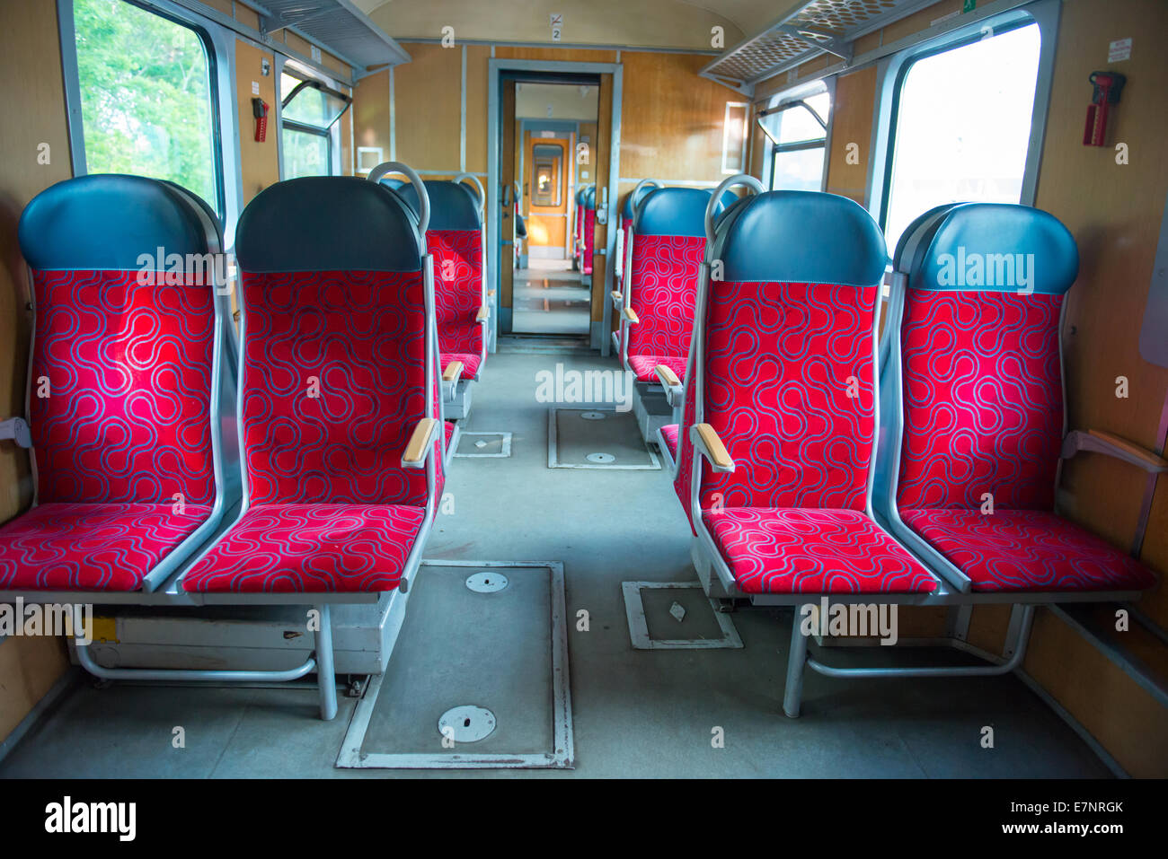 Intérieur d'un train moderne avec des fenêtres et des sièges rouge vide Banque D'Images