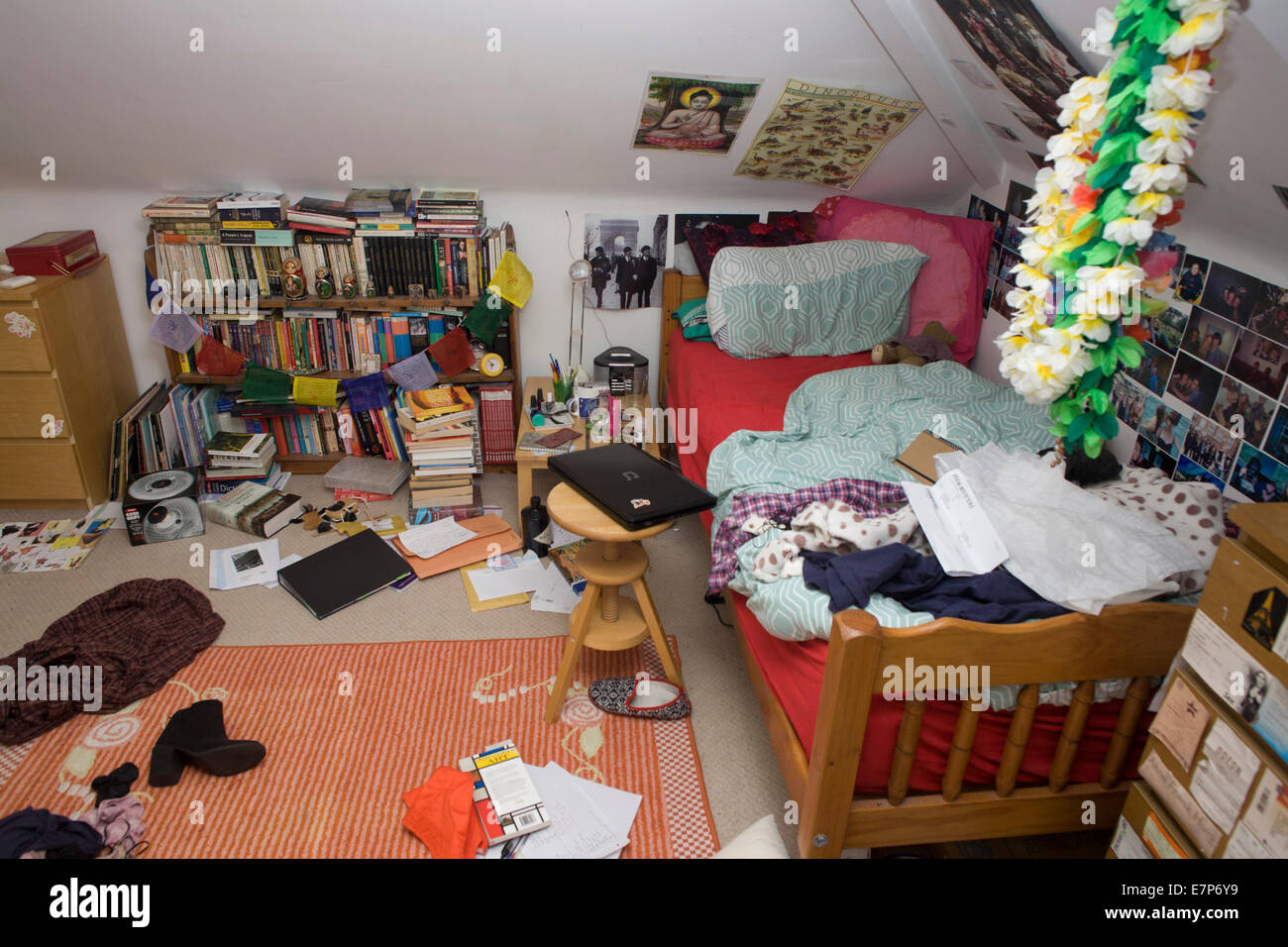 Un adolescent's messy chambre avec des vêtements, des livres et des biens abandonnés sur le sol. Banque D'Images