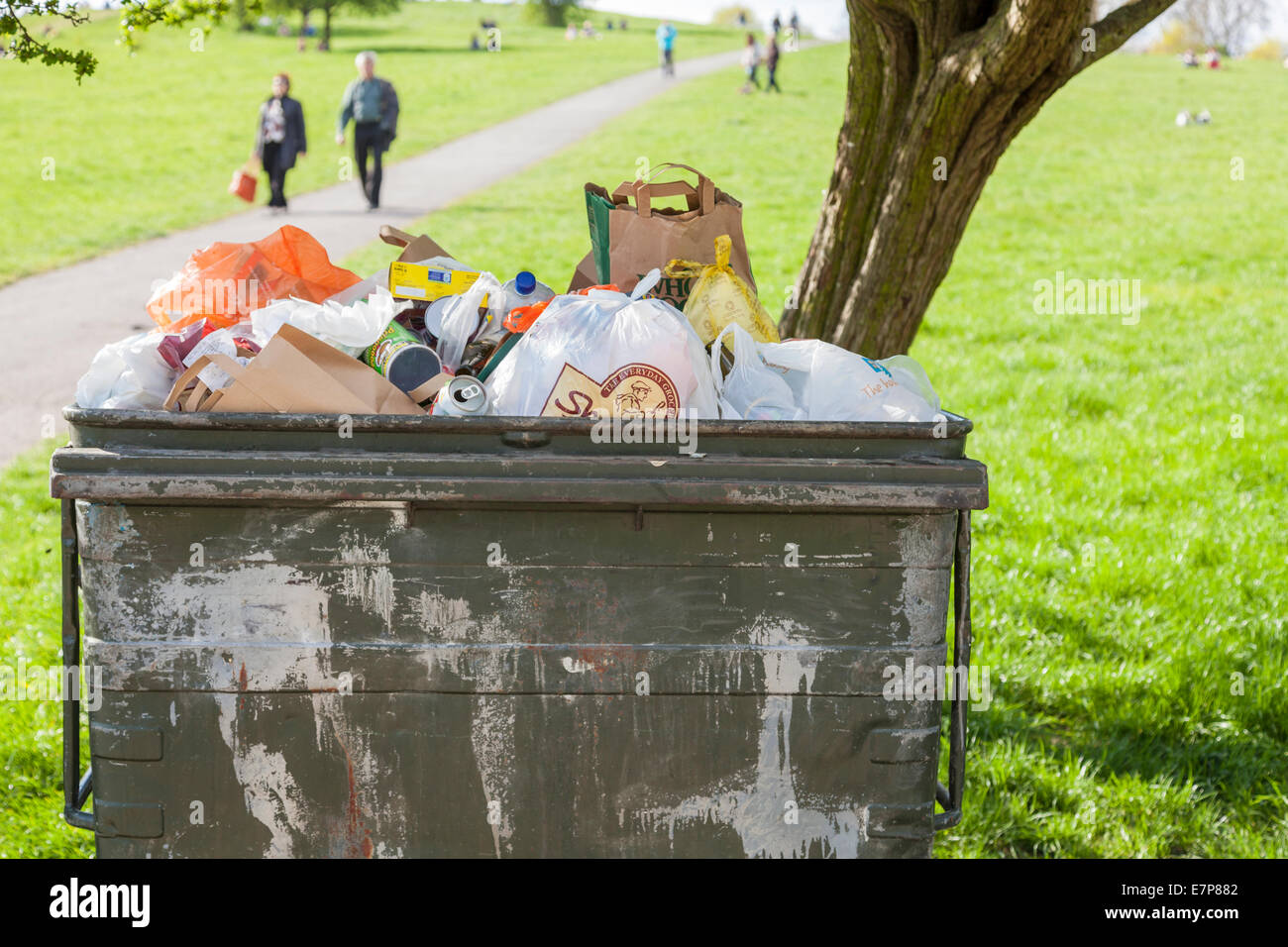 Grand wheelie bin plein de déchets dans un parc à Londres, Angleterre, RU Banque D'Images