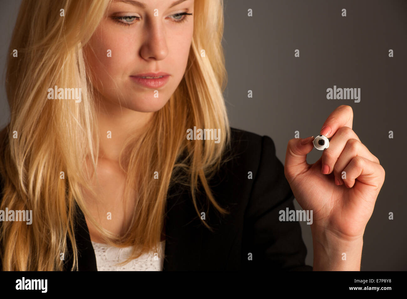 Femme d'affaires blonde aux yeux bleus, écrit sur une table en verre avec le marqueur présentant des occasions d'affaires Banque D'Images