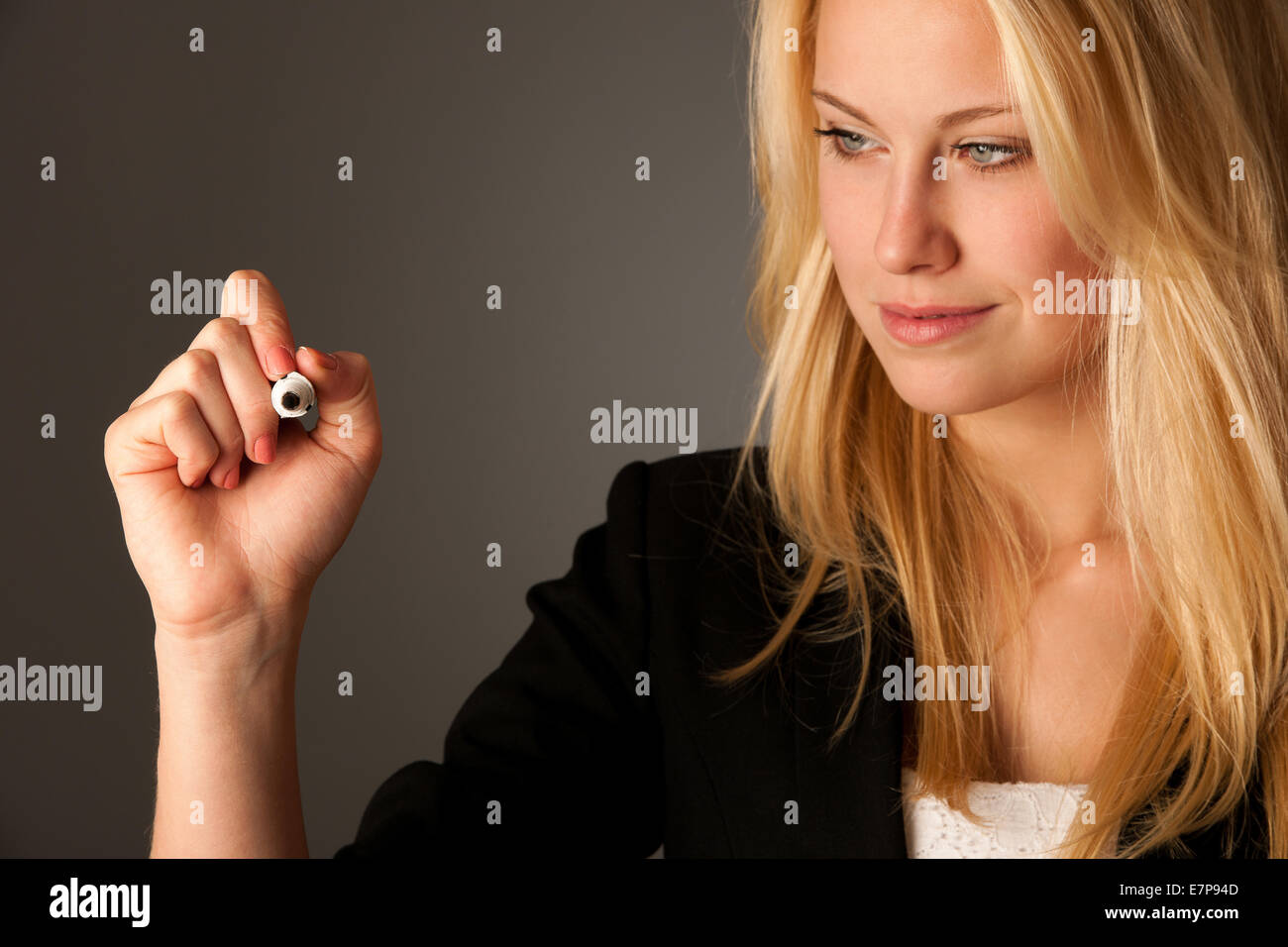 Femme d'affaires blonde aux yeux bleus, écrit sur une table en verre avec le marqueur présentant des occasions d'affaires Banque D'Images