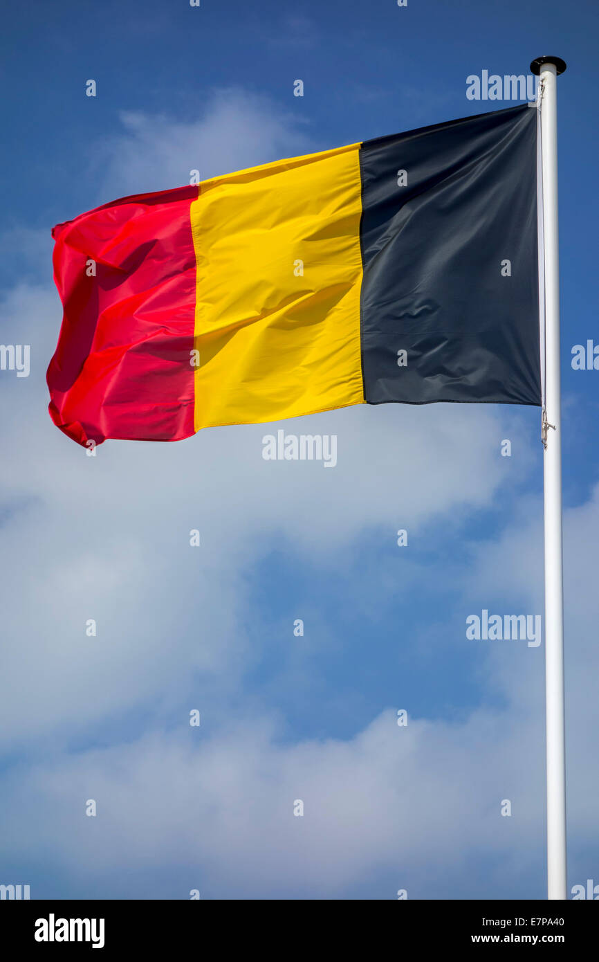 Drapeau national belge de la Belgique le mât au vent contre ciel nuageux Banque D'Images
