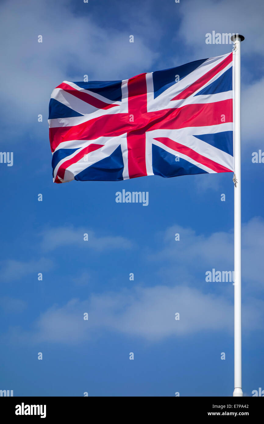 Union Jack / drapeau national du Royaume-Uni le mât au vent contre ciel nuageux Banque D'Images