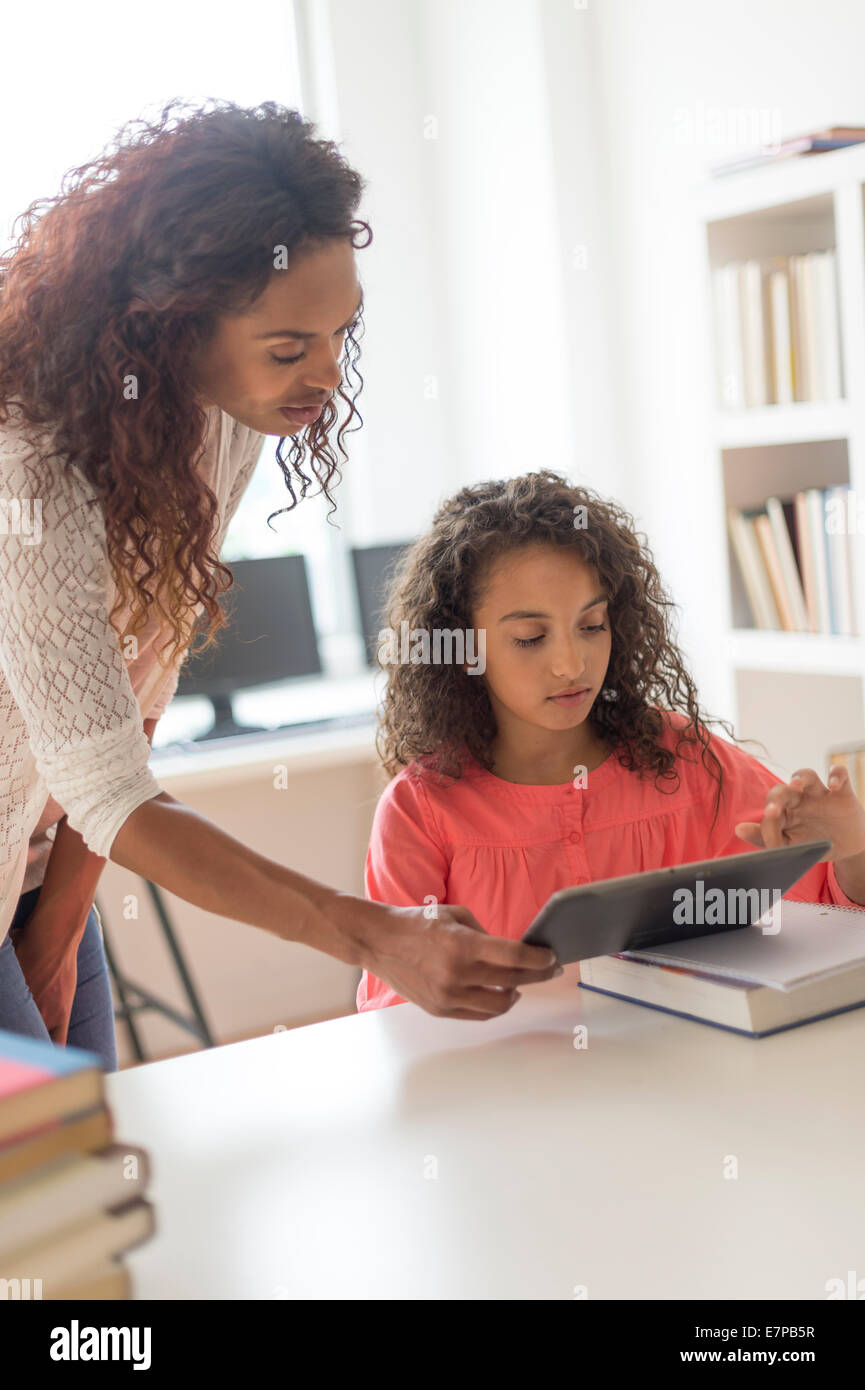 Girl (8-9) et enseignant à l'aide de digital tablet in classroom Banque D'Images